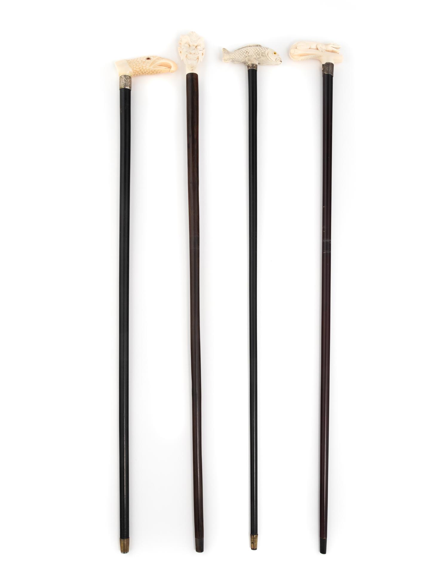 A Group of Four Carved Resin Walking Sticks