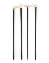 A Group of Four Carved Resin Walking Sticks