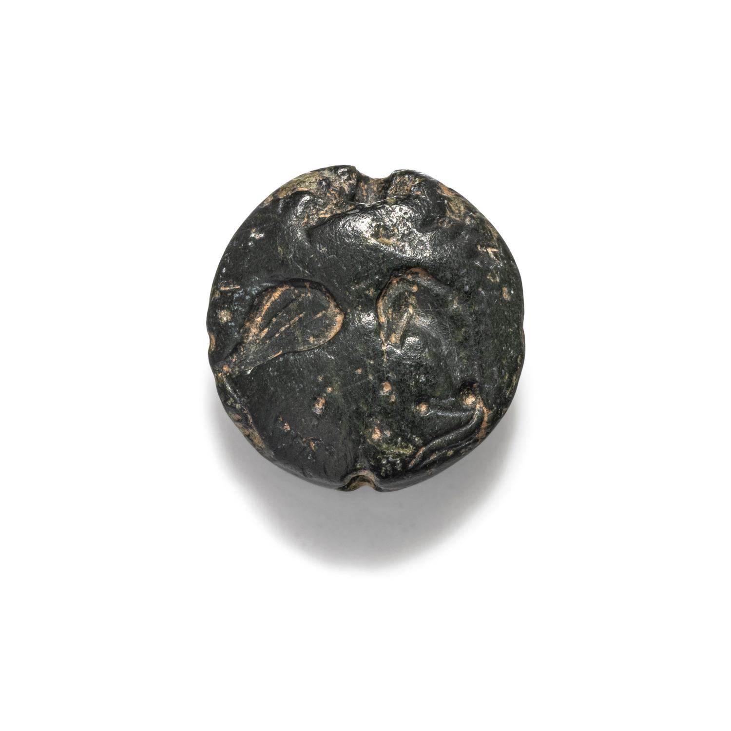 A Minoan Black Steatite Lentoid with a Bull Head and Leaf.