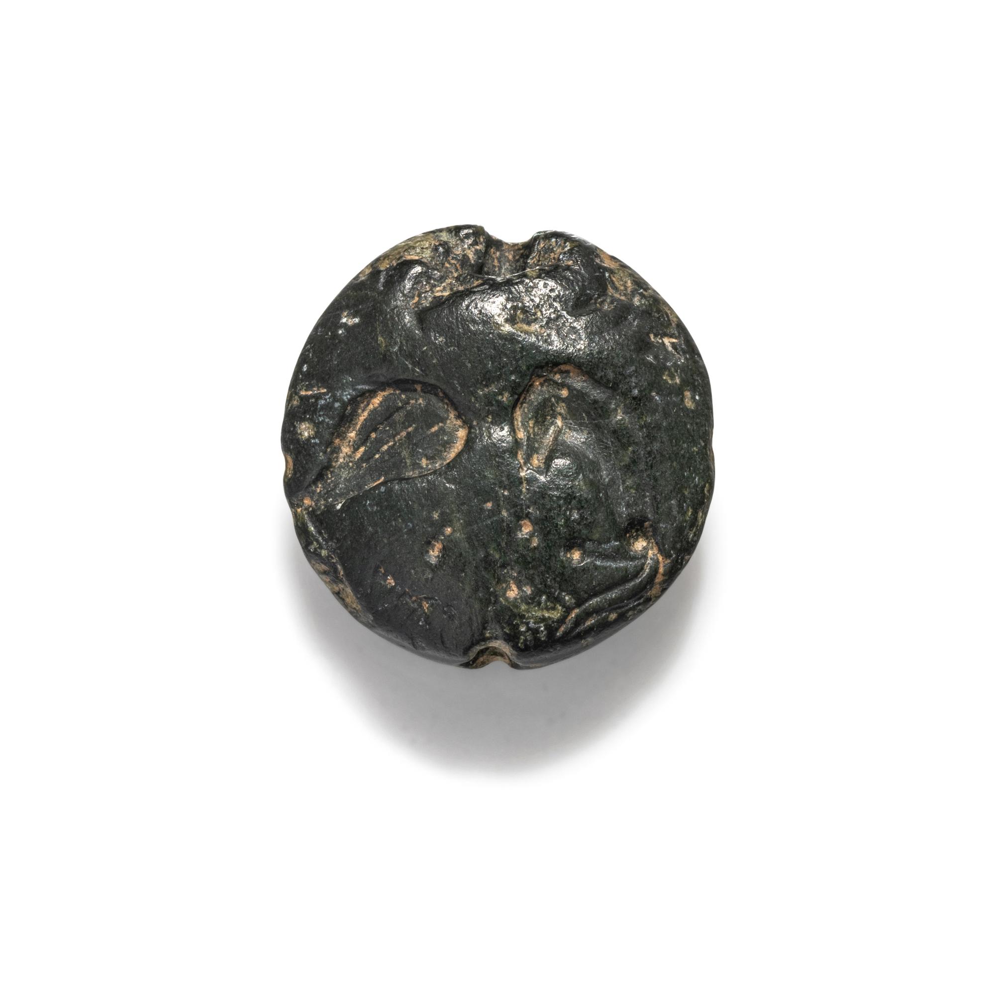 A Minoan Black Steatite Lentoid with a Bull Head and Leaf.