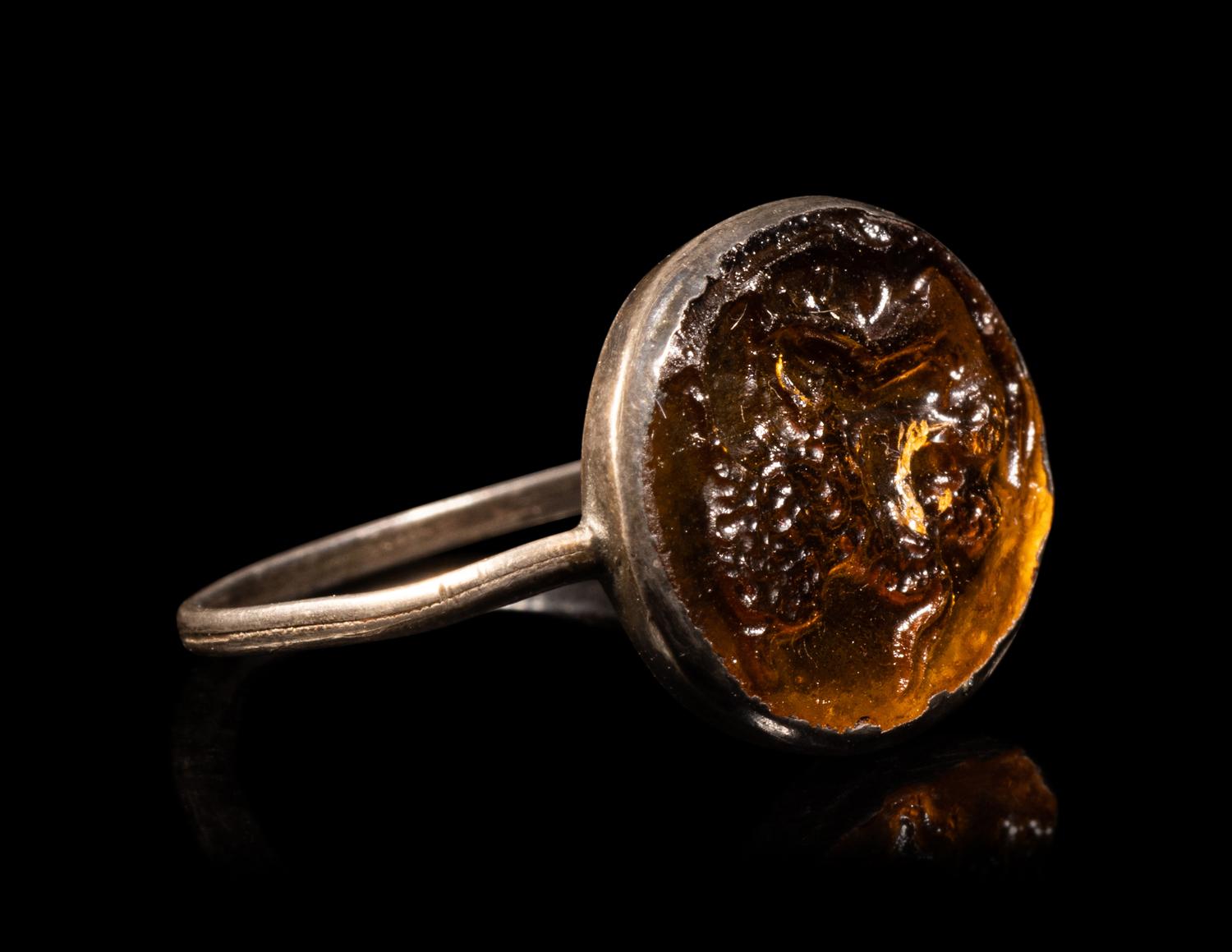 A Roman Silver and Glass Finger Ring of a Satyr Kissing a Goat