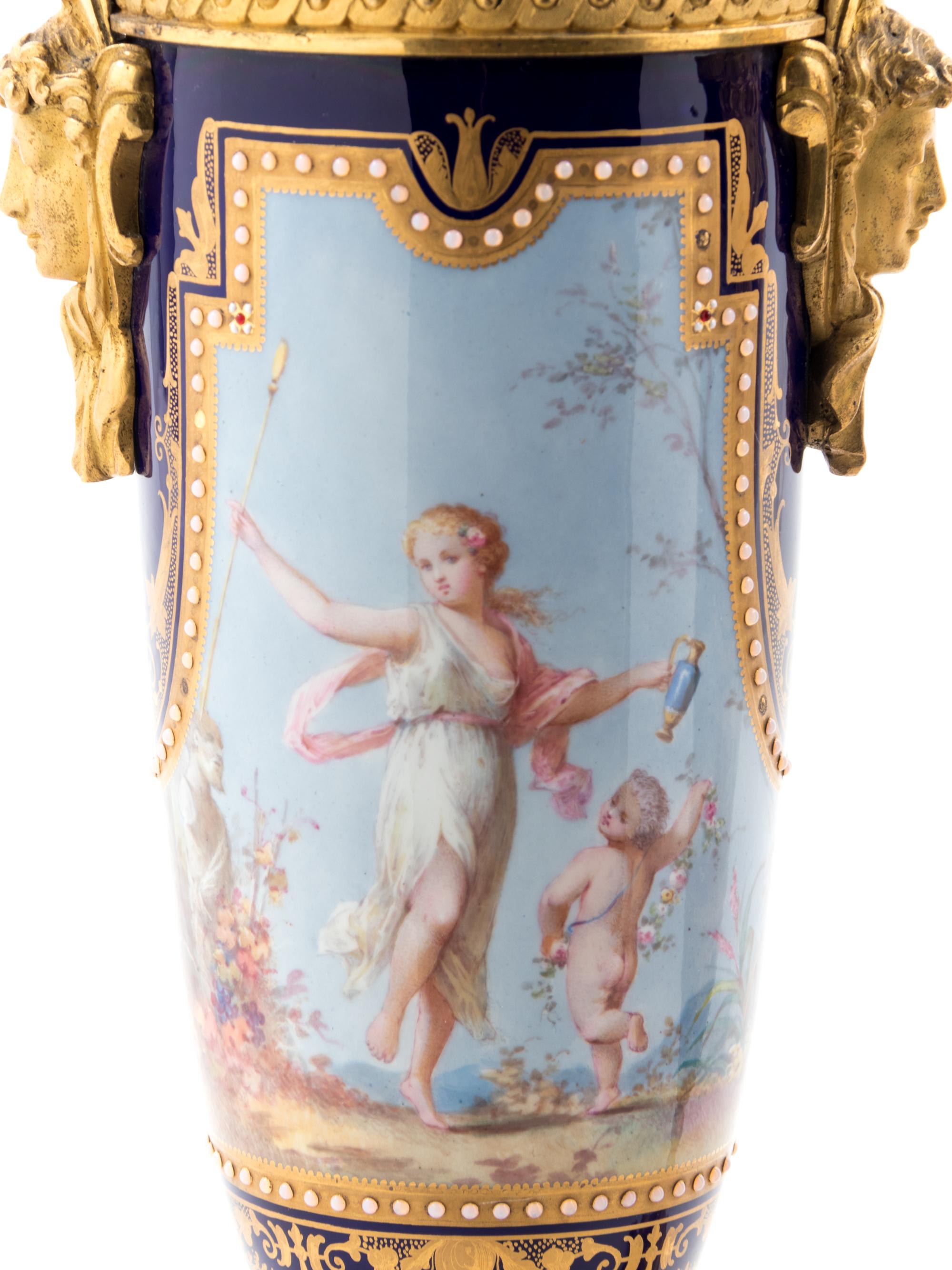 A Pair of Sèvres Style Gilt Bronze Mounted Painted, Parcel Gilt and "Jeweled" Porcelain Urns