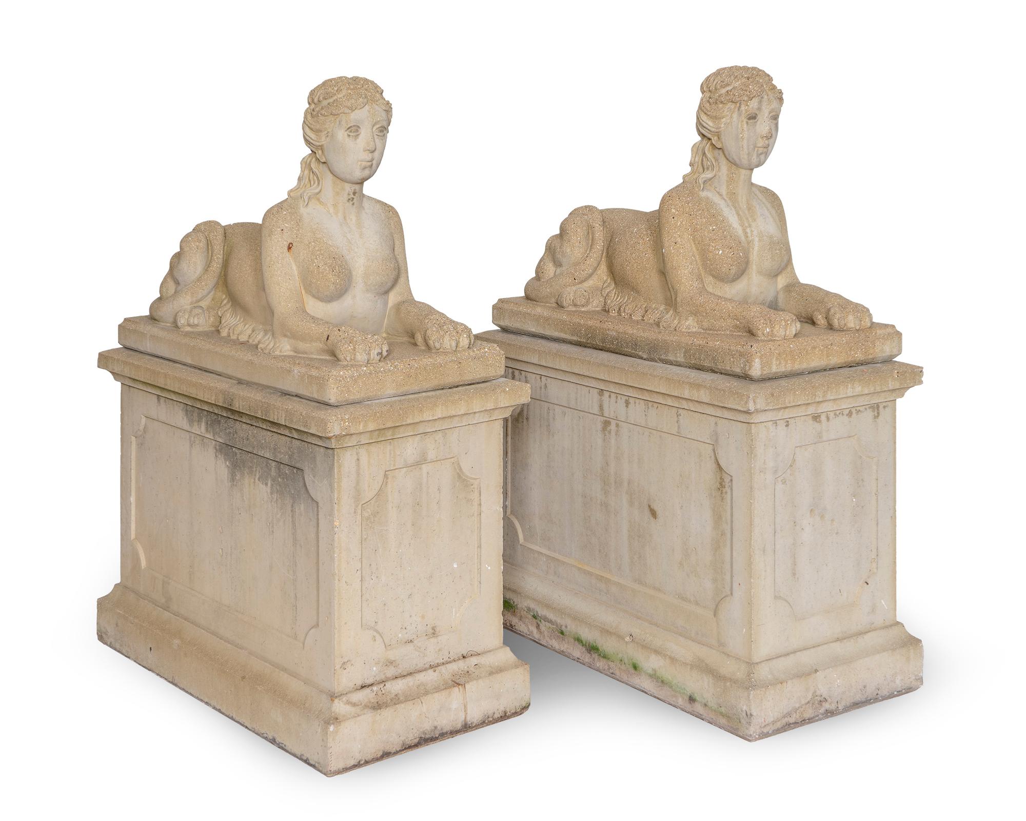 A Pair of Cast Stone Female Sphinxes on Pedestal Bases — 20TH CENTURY
