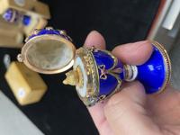 A 14 Karat Vari-Color Gold, Guilloché Enamel, Diamond, and Cabochon Jewel-Mounted Egg-Form Perfume and a Related Guilloché Enamel, 14 Karat Vari-Color Gold, Diamond, and Cabochon-Mounted Surprise Egg