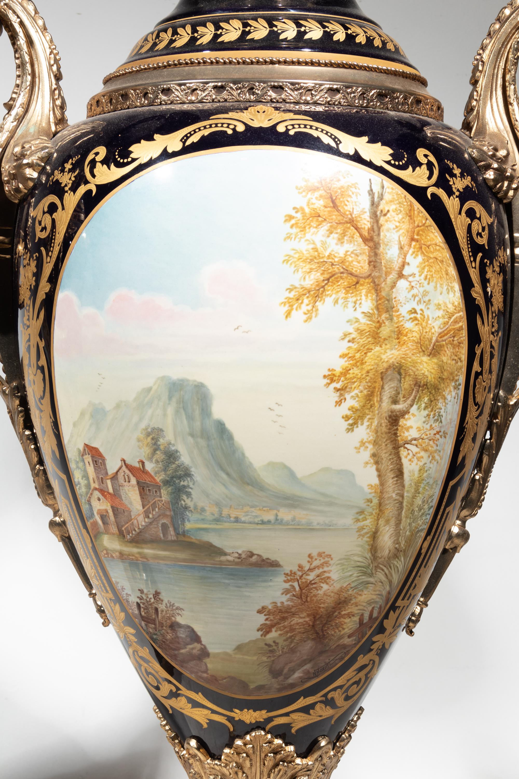 A Pair of Monumental Sèvres Style Gilt Metal Mounted Porcelain Covered Urns on Pedestals