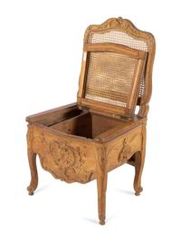 A Louis XV Provincial Carved Fruitwood Commode Chair