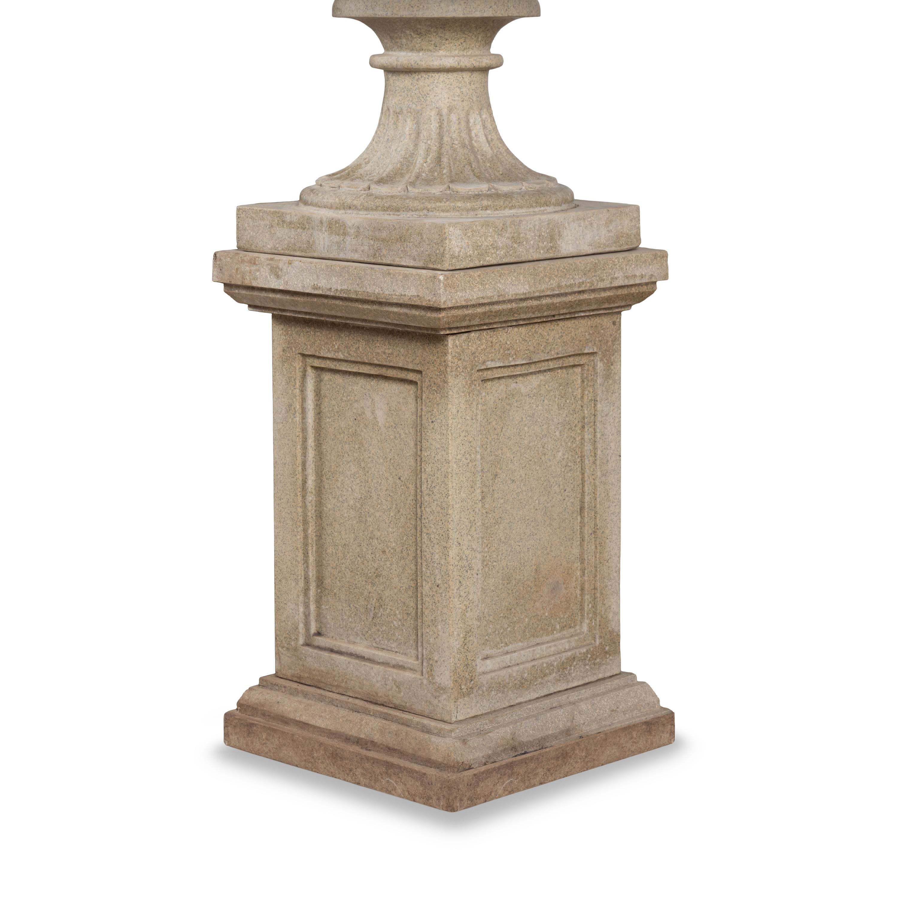 A Pair of Carved Granite Urns and Plinths