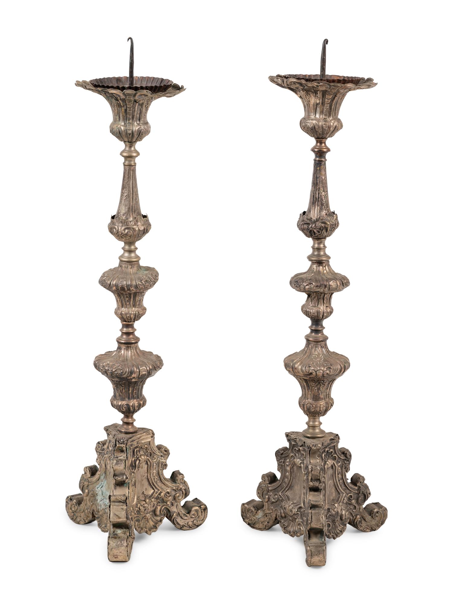 A Pair of Baroque Repoussé Decorated Silvered Metal Pricket Sticks