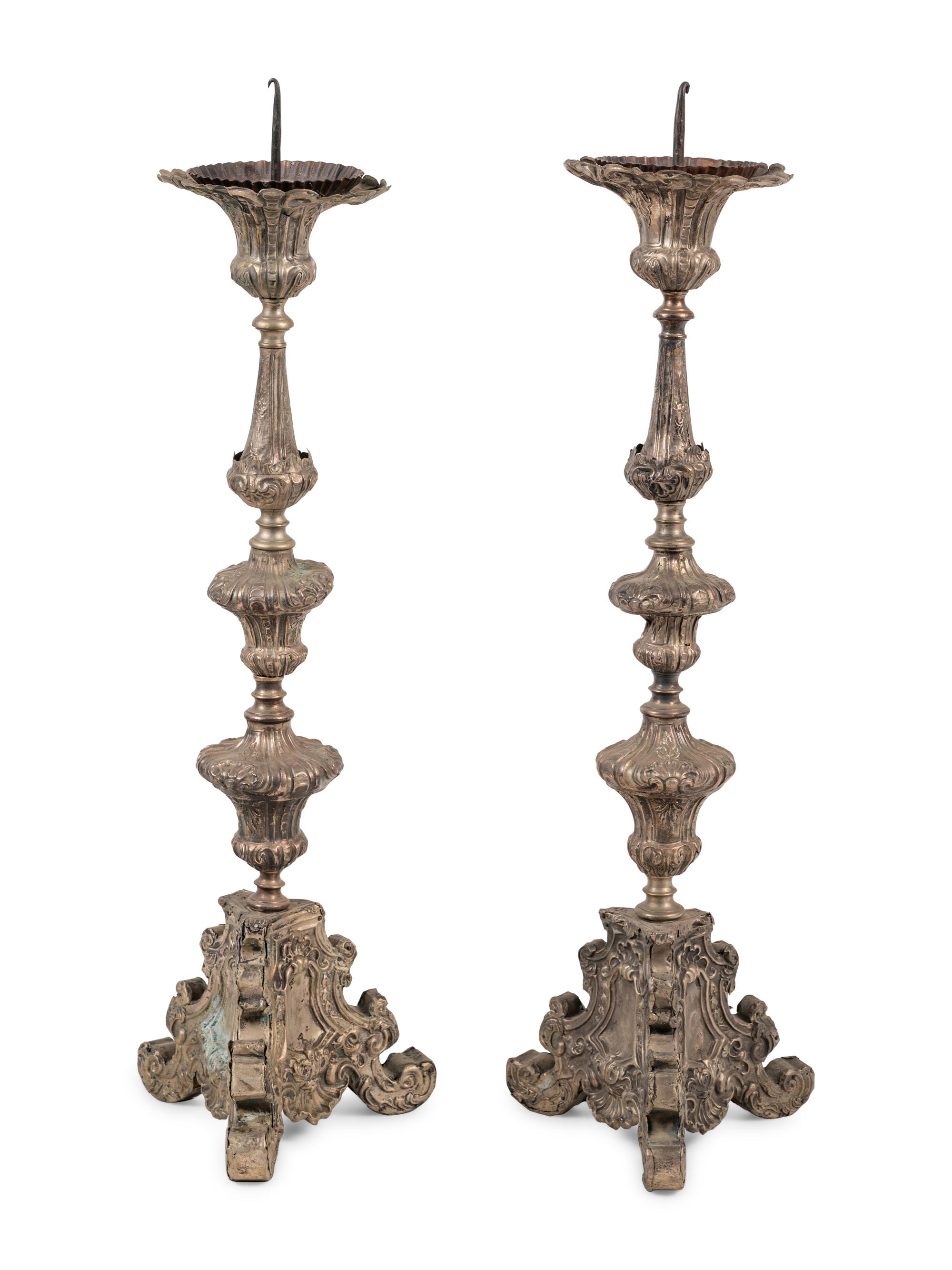 A Pair of Baroque Repoussé Decorated Silvered Metal Pricket Sticks