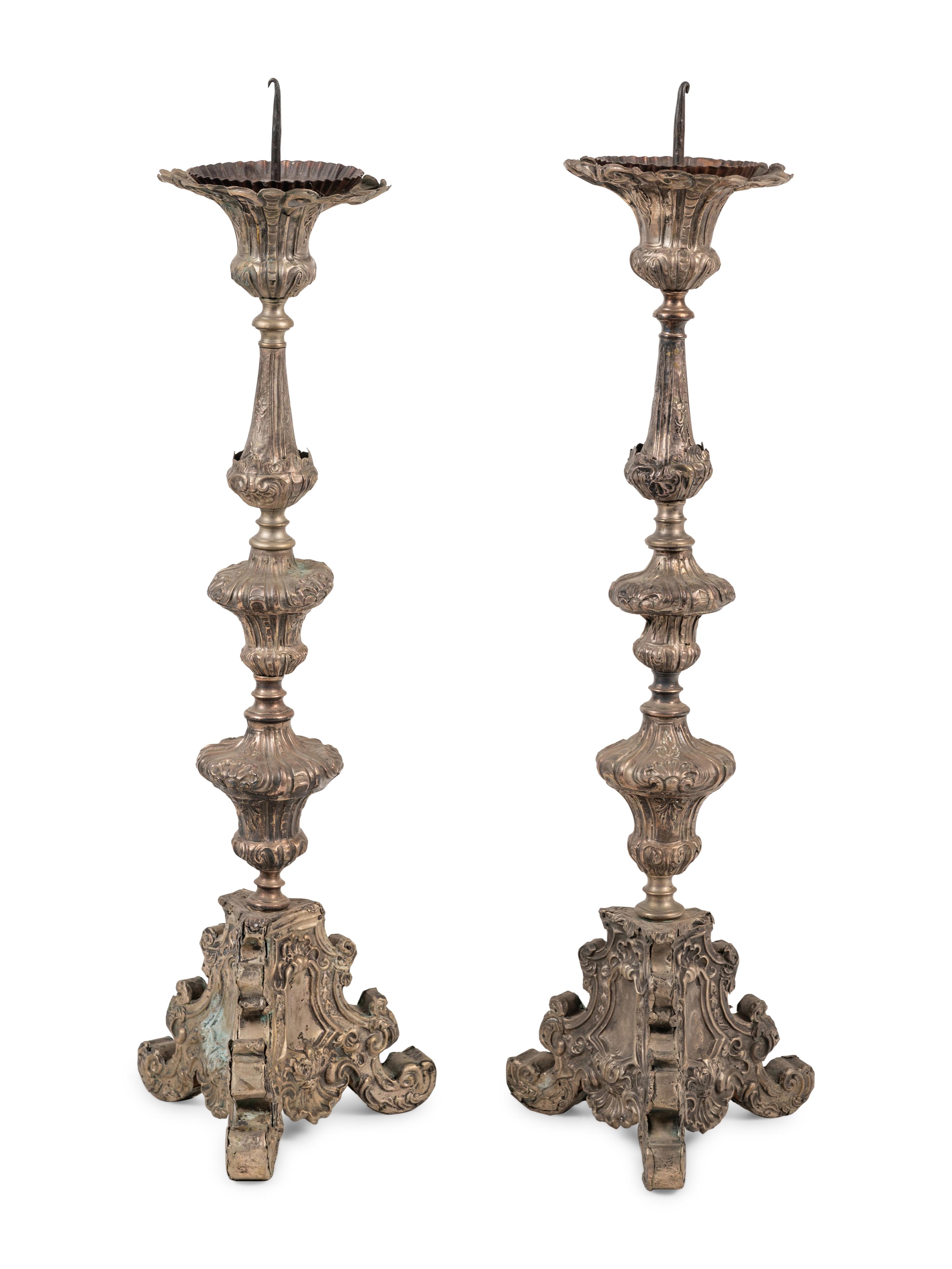 A Pair of Baroque Repoussé Decorated Silvered Metal Pricket Sticks