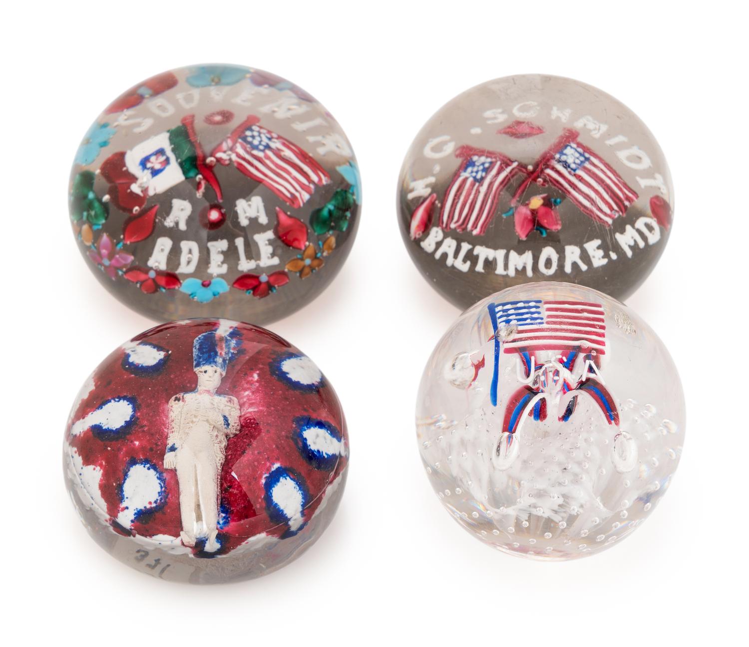 Two Union Glass Co. Flag and Flowers Commemorative Glass Paperweight, an American Flag U.S.A. Glass Paperweight and a Red, White and Blue Soldier Glass Paperweight