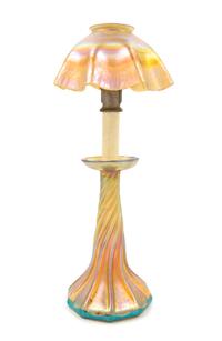 Tiffany Studios, EARLY 20TH CENTURY, a Favrile glass candlestick lamp, in gold iridescence, having ruffled shade and twist base