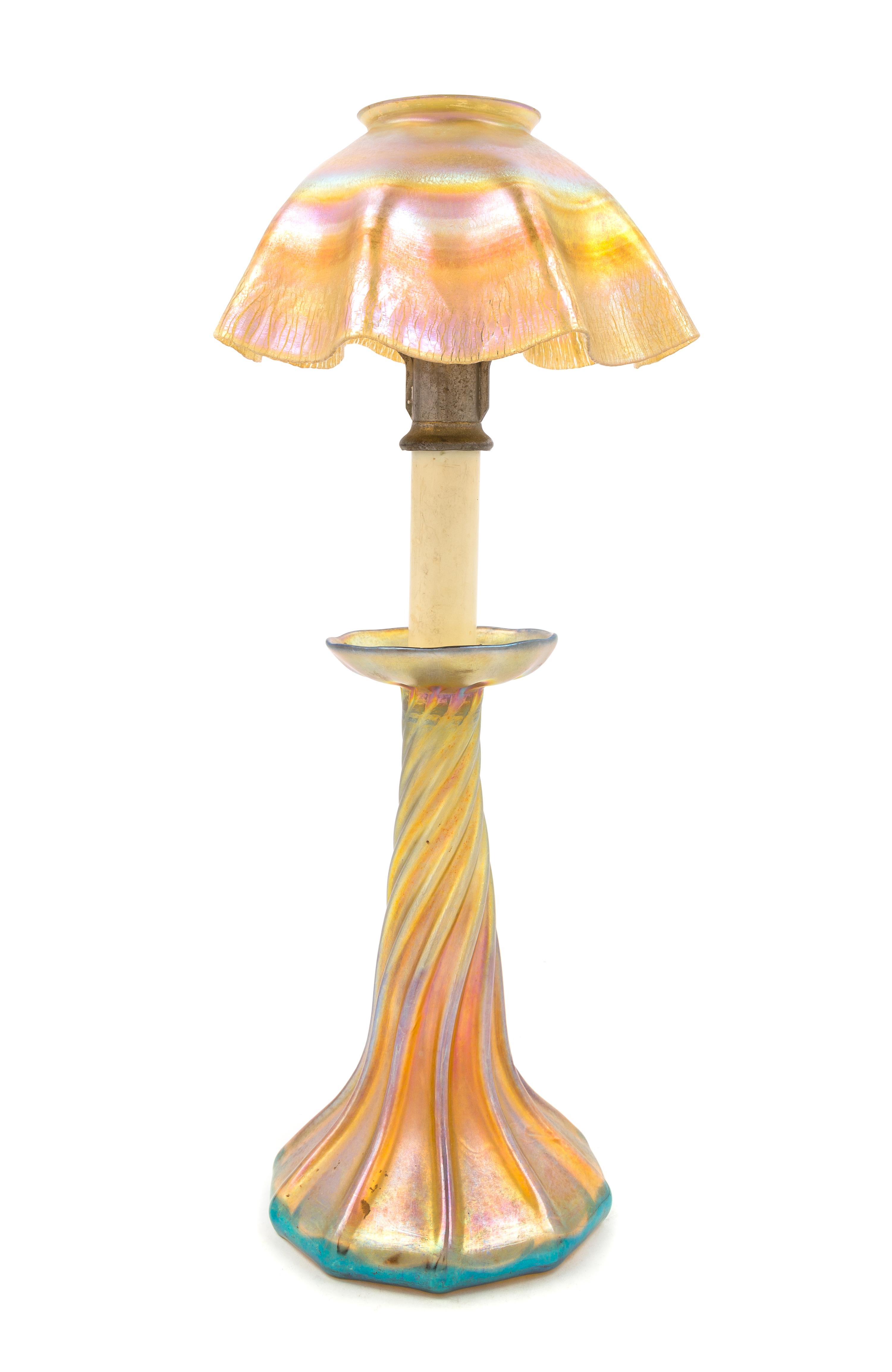 Tiffany Studios, EARLY 20TH CENTURY, a Favrile glass candlestick lamp, in gold iridescence, having ruffled shade and twist base