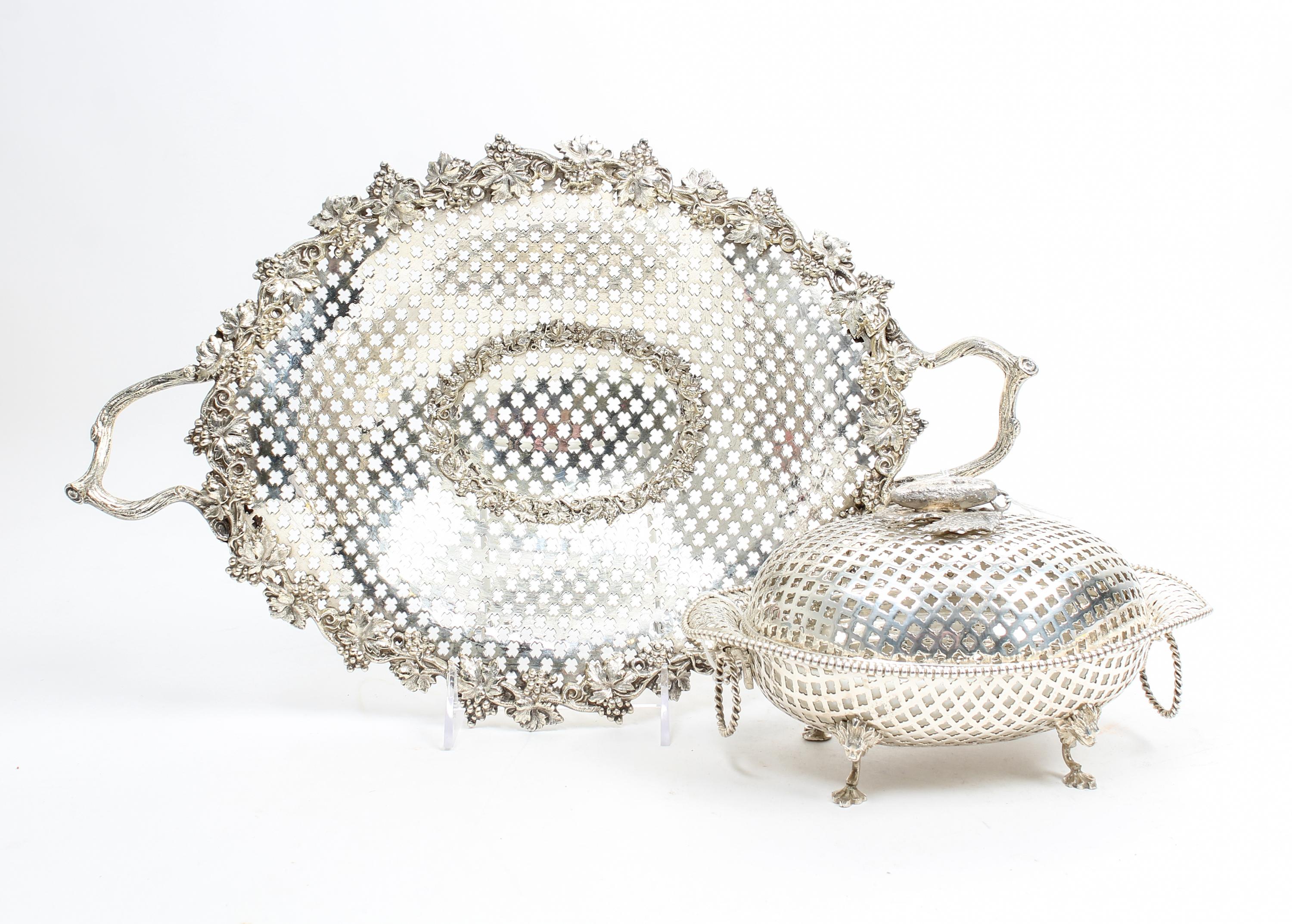 Two Silvered Metal Reticulated Table Articles, , comprising a center basket with pierced body, the rim decorated with grape leaf and cl