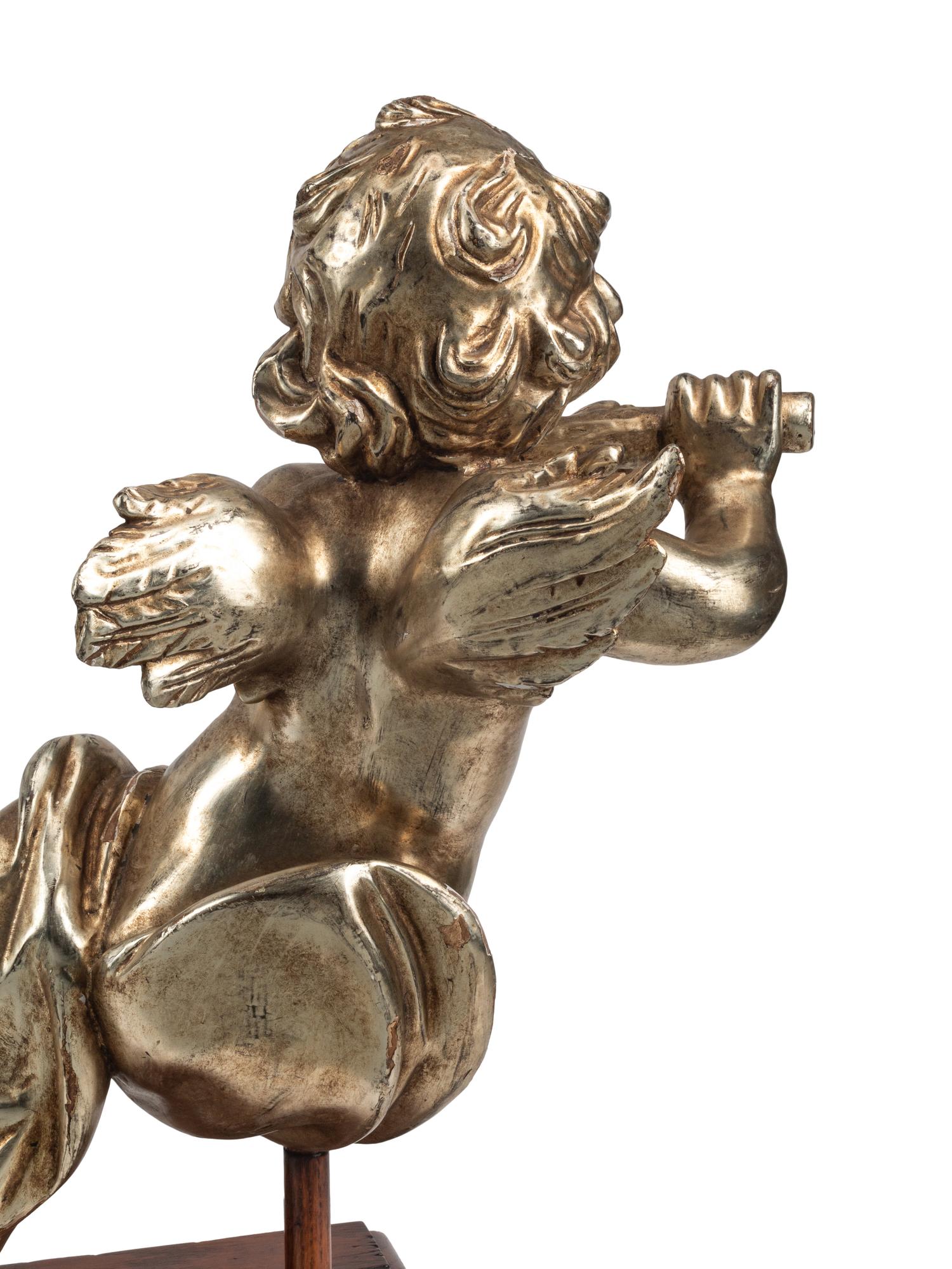 A Pair of Silvered Wood Musical Putto Ornaments