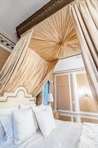 An Italian Carved Giltwood Bedstead with Baldachin, Headboard and Drapes