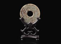 A Chinese archaistic carved mottled grey and russet jade bi disc 玉璧一件