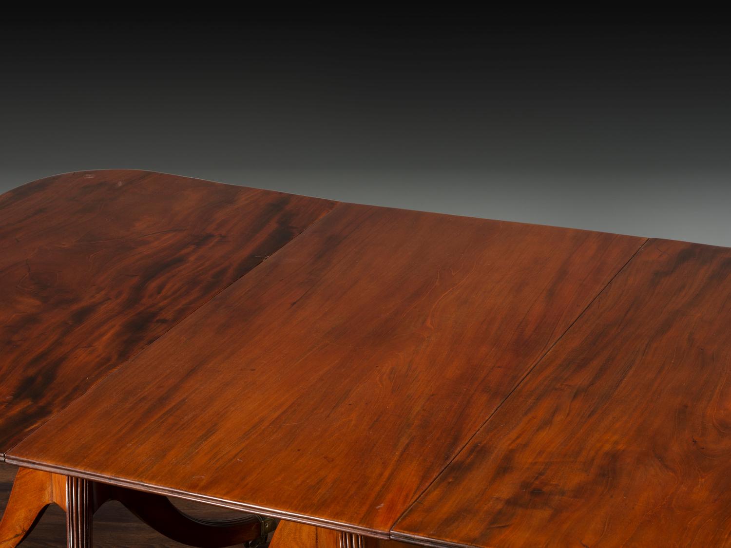 A Late Chippendale Flame Mahogany Triple Pedestal Dining Table