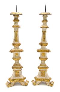 A Pair of Italian Carved, Painted and Parcel Giltwood Pricket Sticks, Height overall 34 1/4 inches.