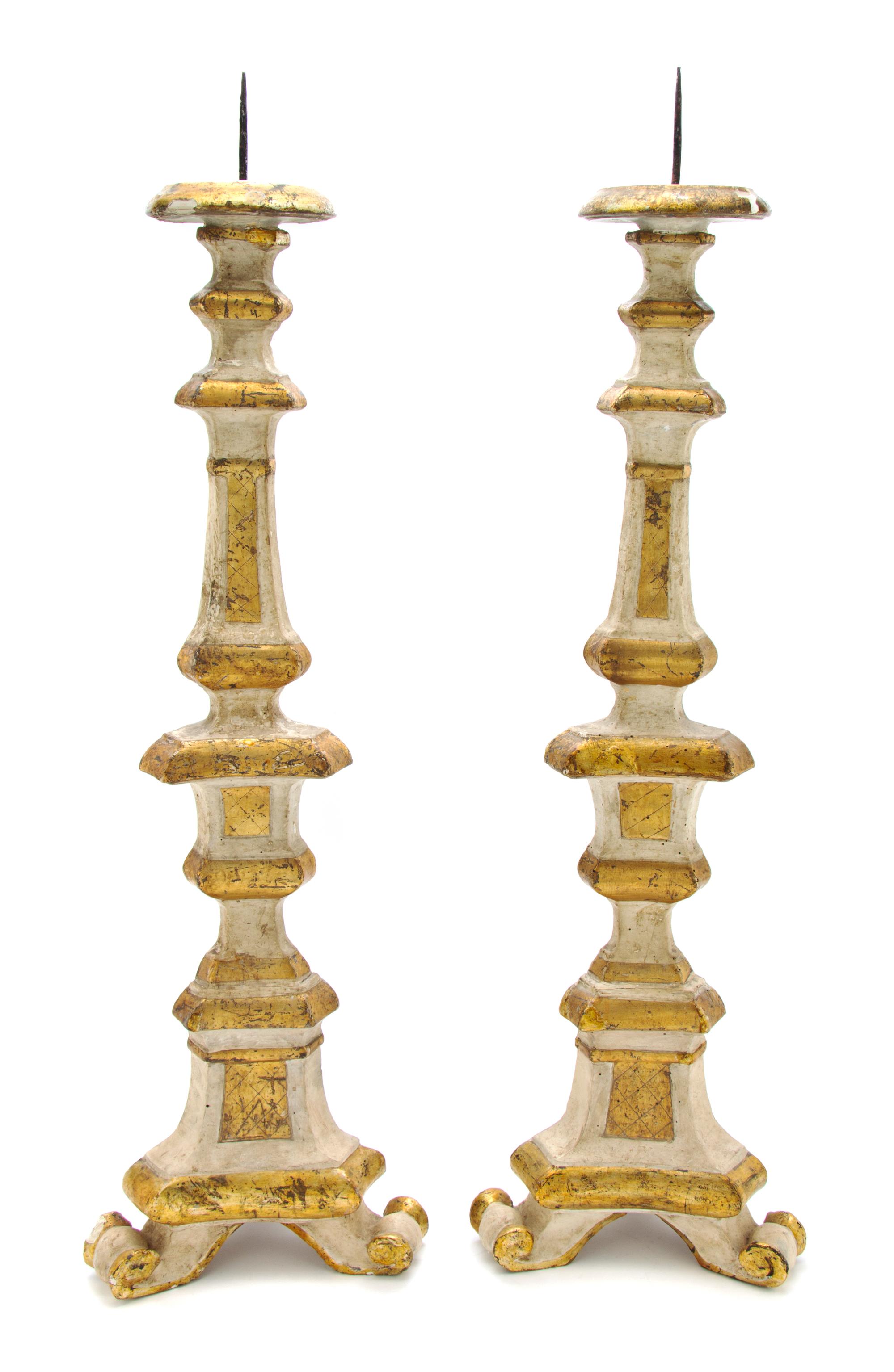 A Pair of Italian Carved, Painted and Parcel Giltwood Pricket Sticks, Height overall 34 1/4 inches.