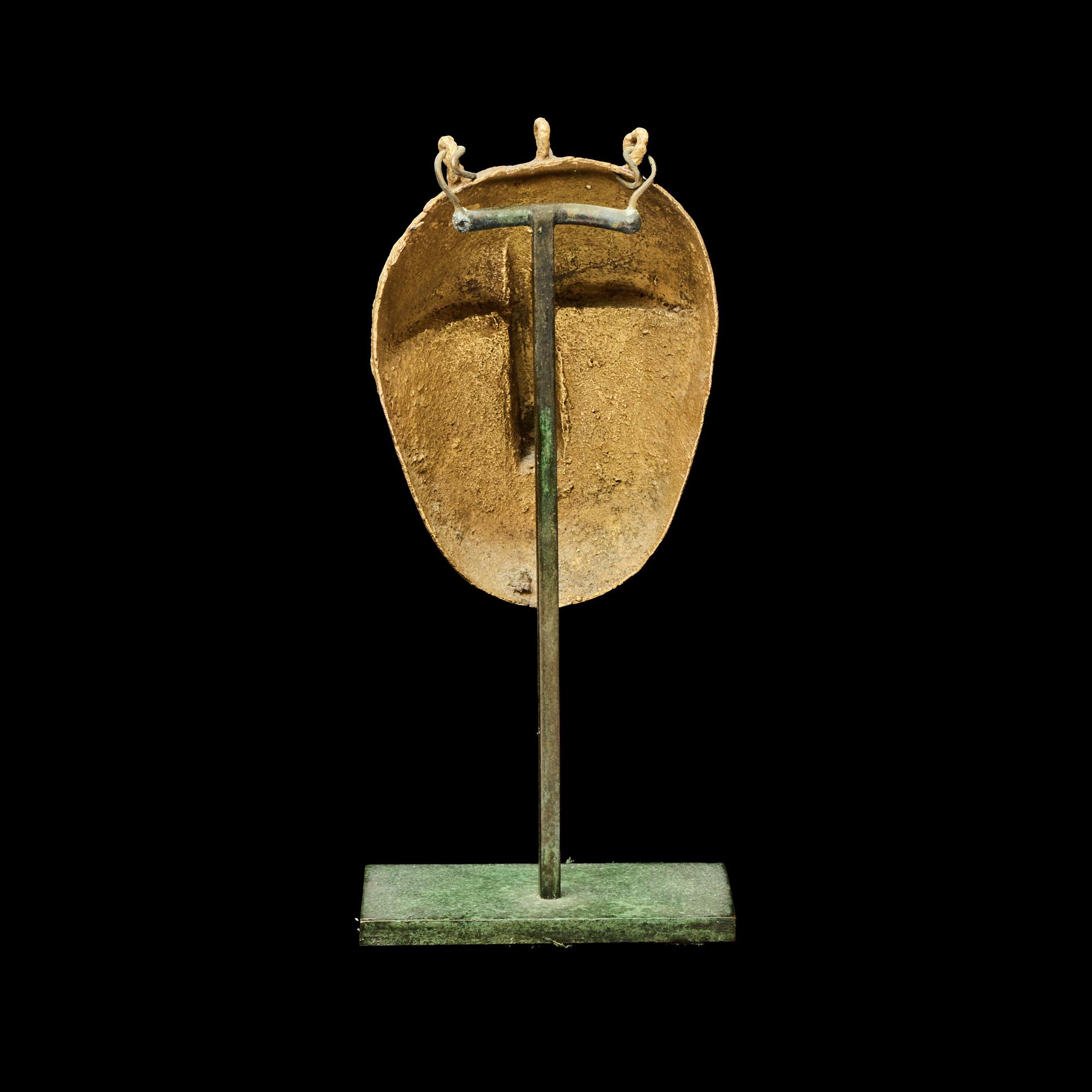 A Lagoons Region Gilt-Brass Mask Pendant