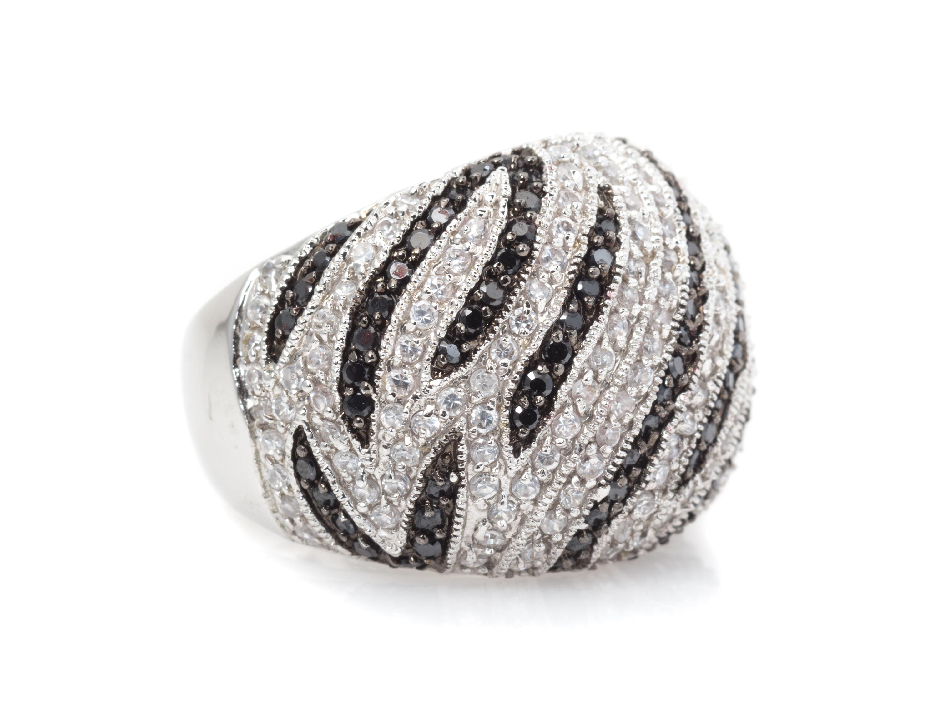 A White Gold, Diamond and Black Diamond Swirl Motif Ring, 11.40 dwts.