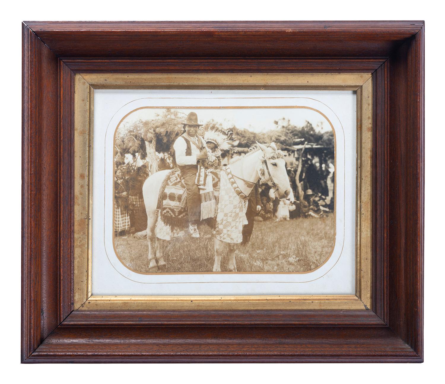 [NATIVE AMERICANS]. Outdoor view of a Native American man and child on horseback.
