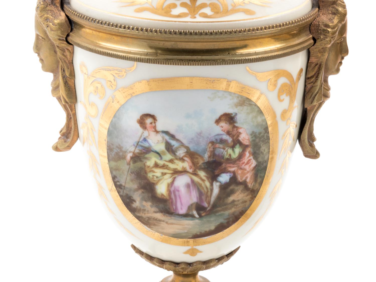 A Pair of Sèvres Style Gilt Bronze Mounted Painted and Parcel Gilt Porcelain Urns