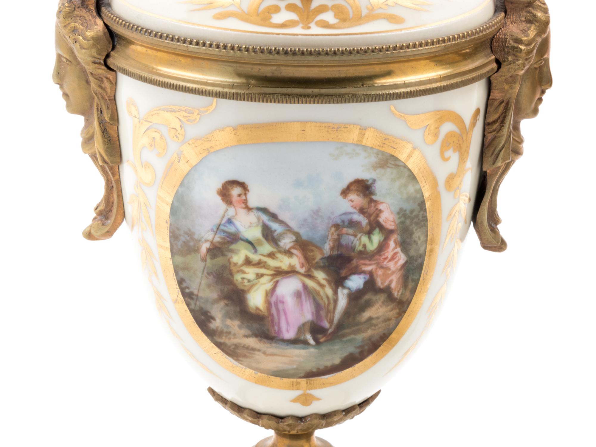 A Pair of Sèvres Style Gilt Bronze Mounted Painted and Parcel Gilt Porcelain Urns