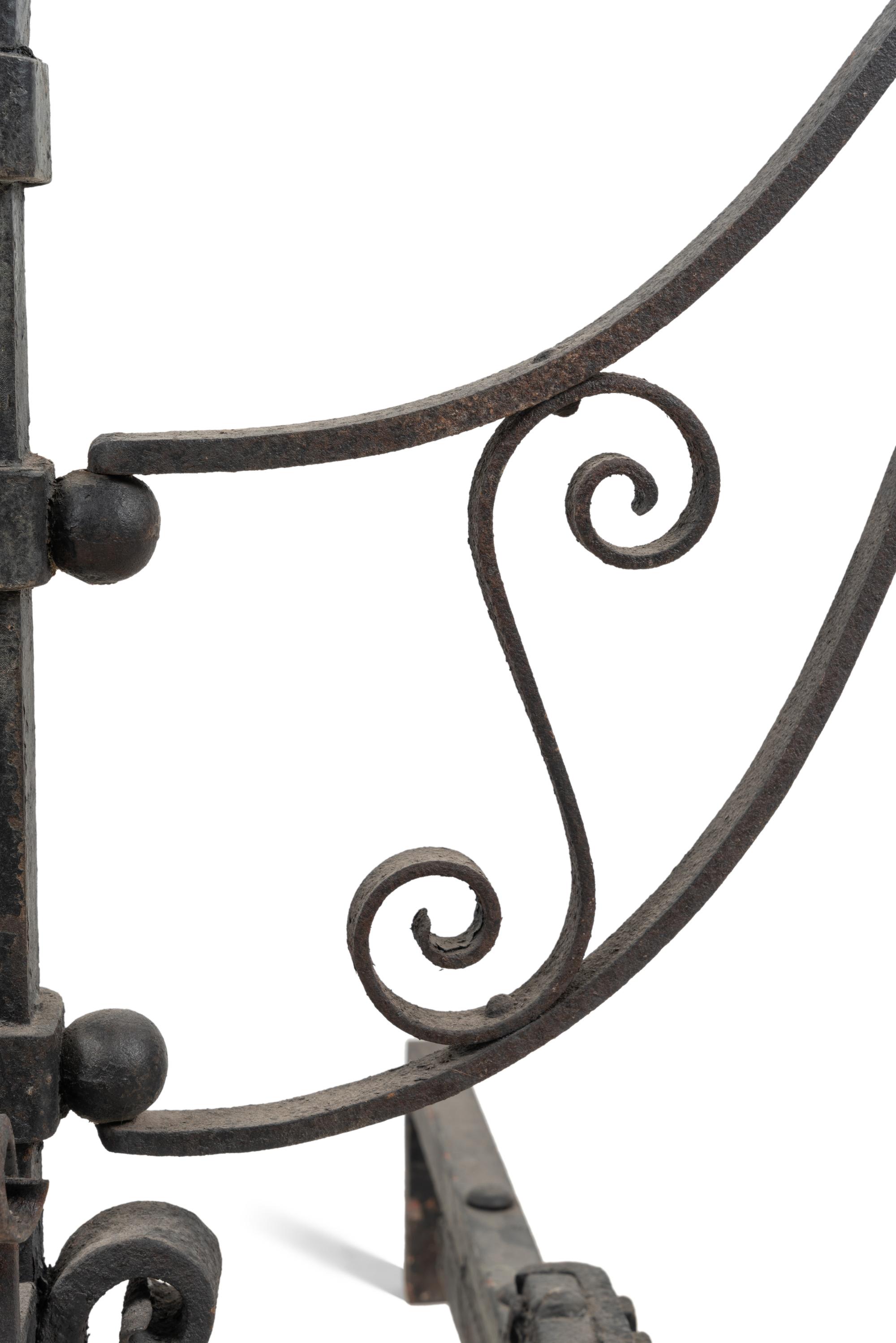 A Pair of Continental Iron Andirons with Posset Cup Holders
