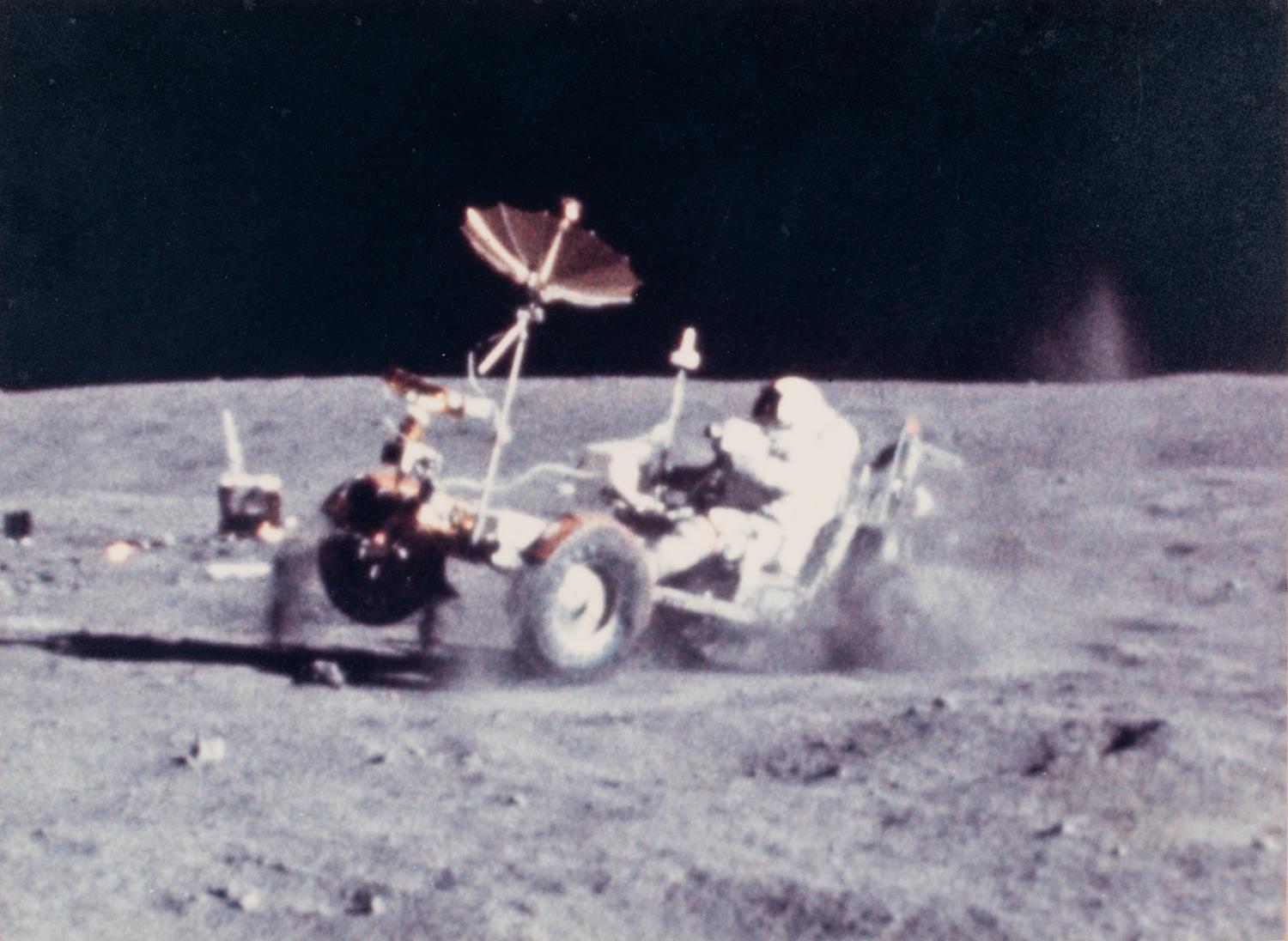 YOUNG, John Watts (1930-2018). Photograph of Young driving a moon buggy, signed (“John Young”) to Ambassador Edward Joseph Perkins.