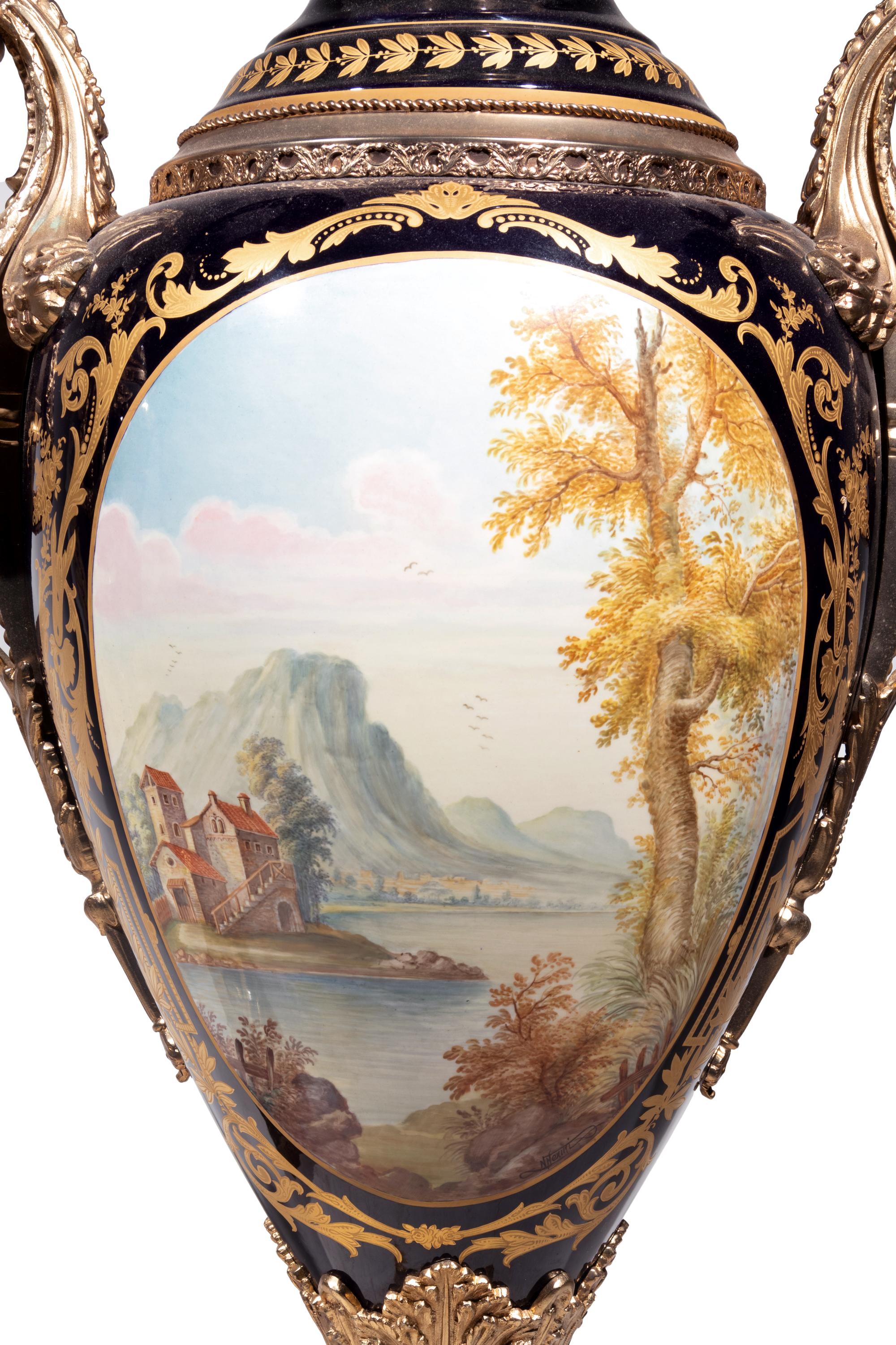 A Pair of Monumental Sèvres Style Gilt Metal Mounted Porcelain Covered Urns on Pedestals