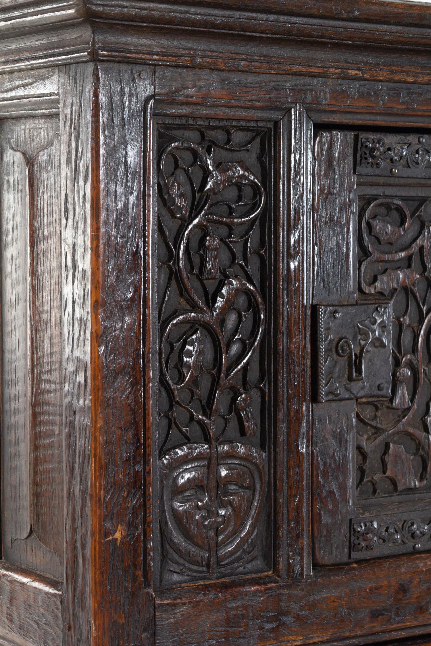 A Gothic Revival Carved Oak Cabinet on Stand