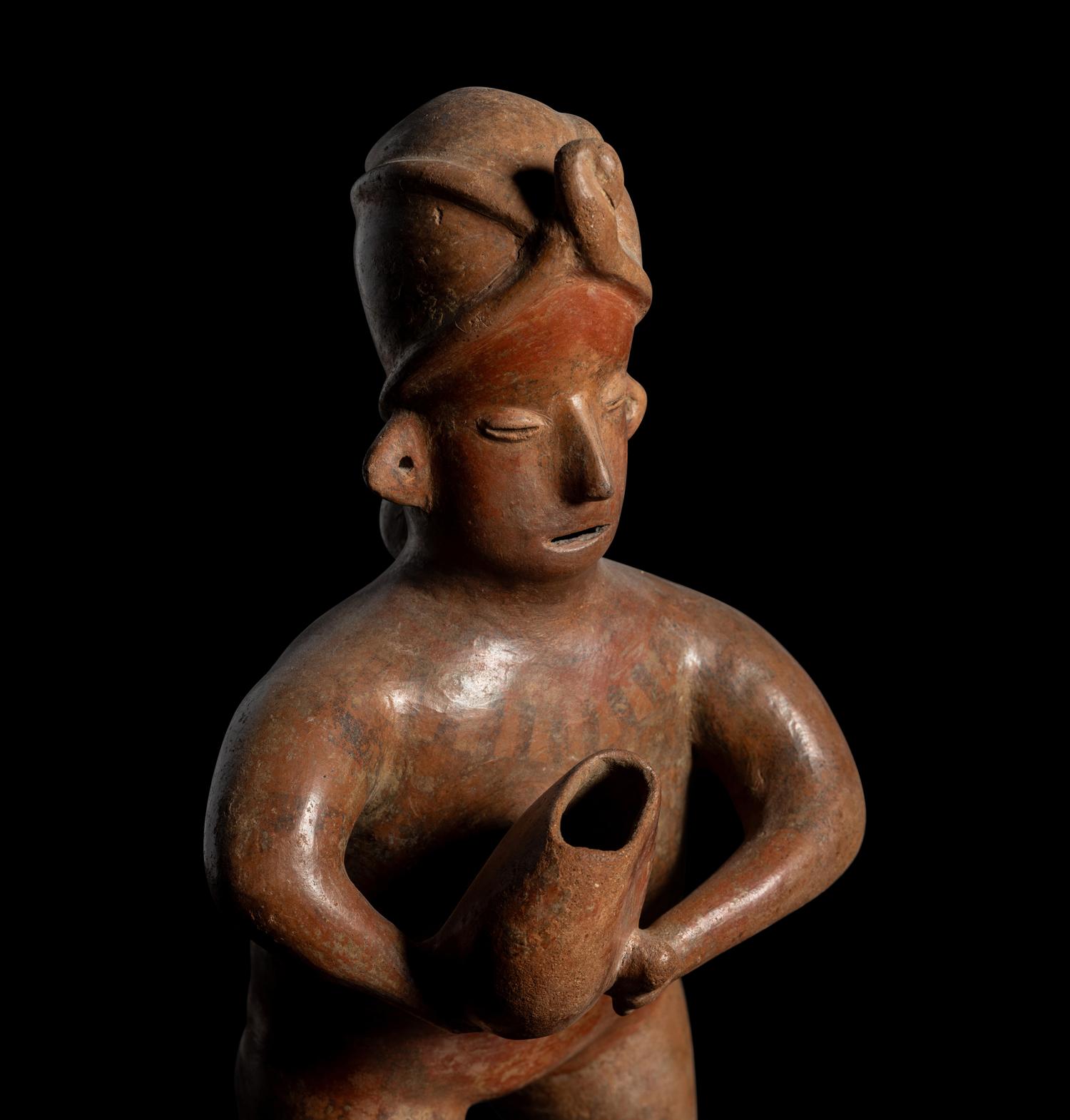 A Colima Standing Figure Holding a Pot