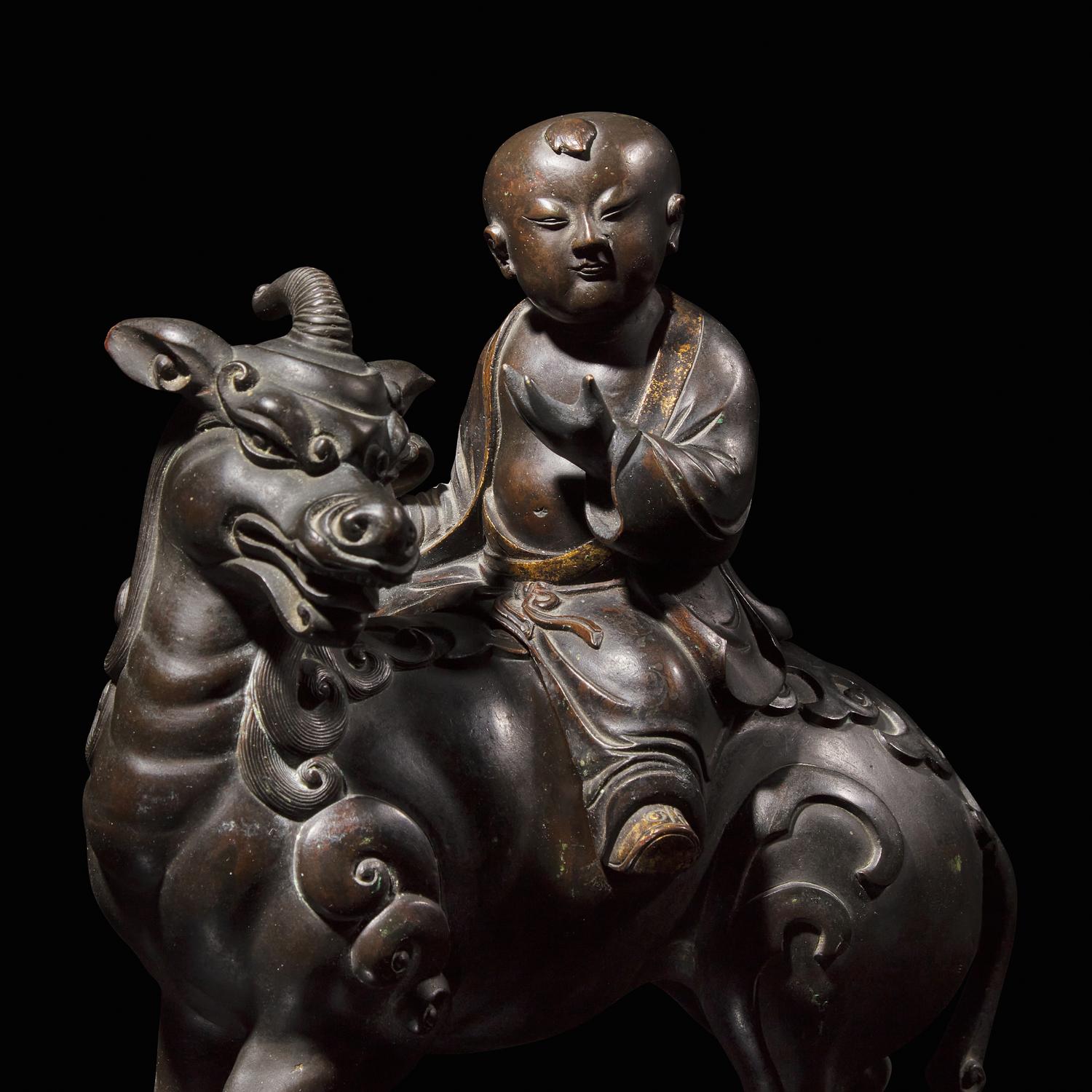 A Chinese Patinated and Parcel-gilt Bronze 'Qilin and Boy' Censer, 17th/18th Century 清早期 銅局部鎏金麒麟童子香薰