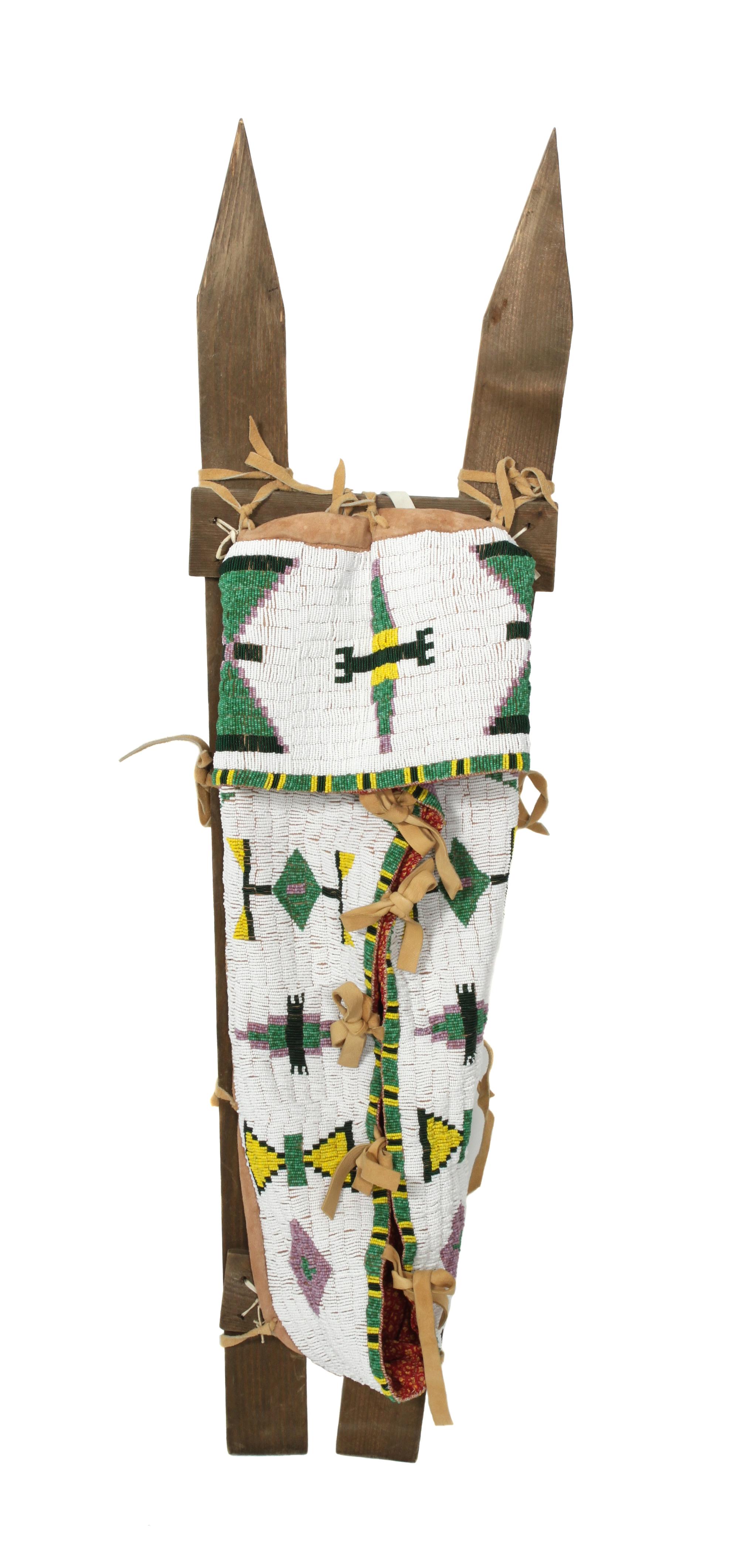 A Northern Plains Style Beaded Cradle on Sticks Length overall 42 inches