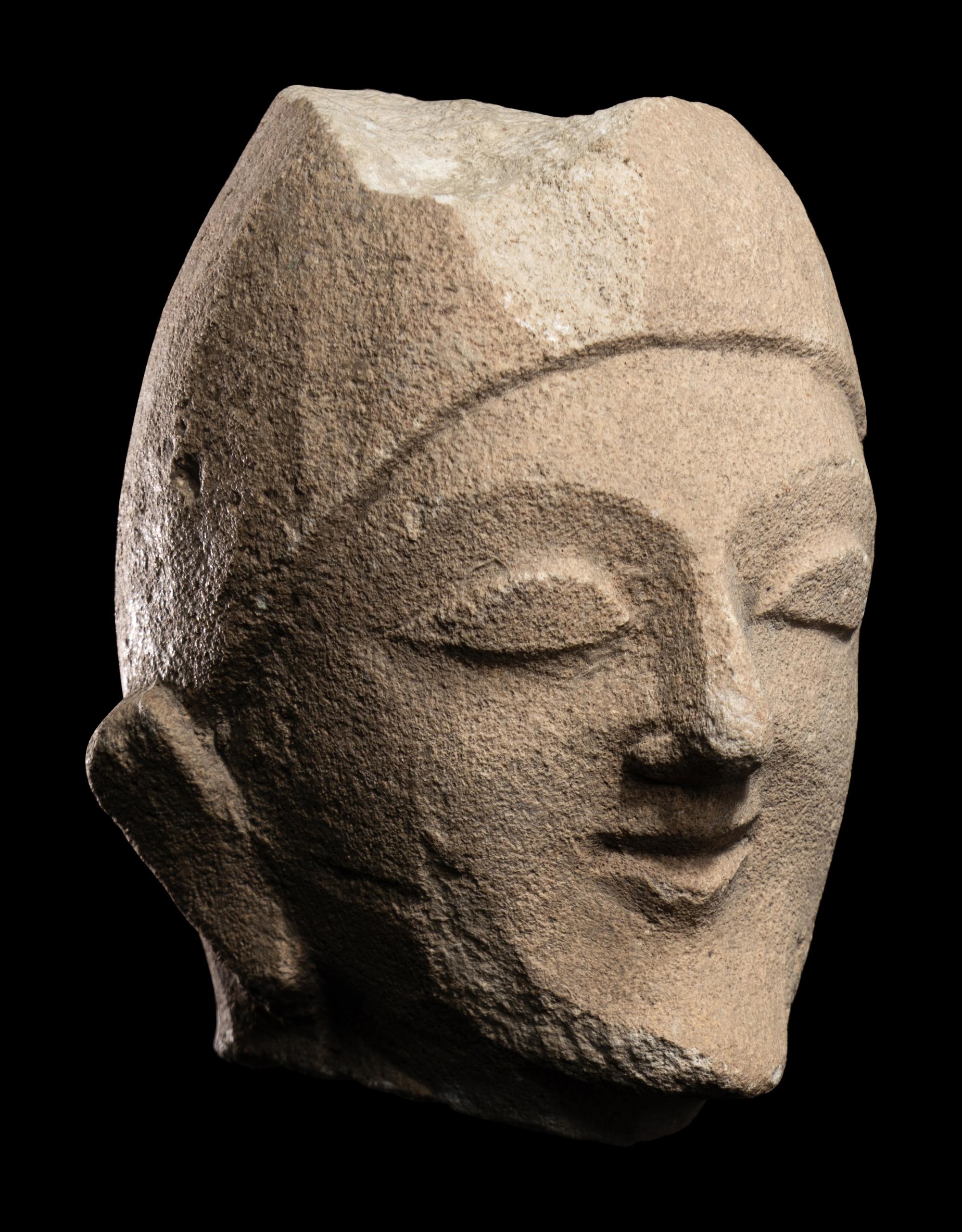 A Cypriot Limestone Head of a Man Wearing a Helmet