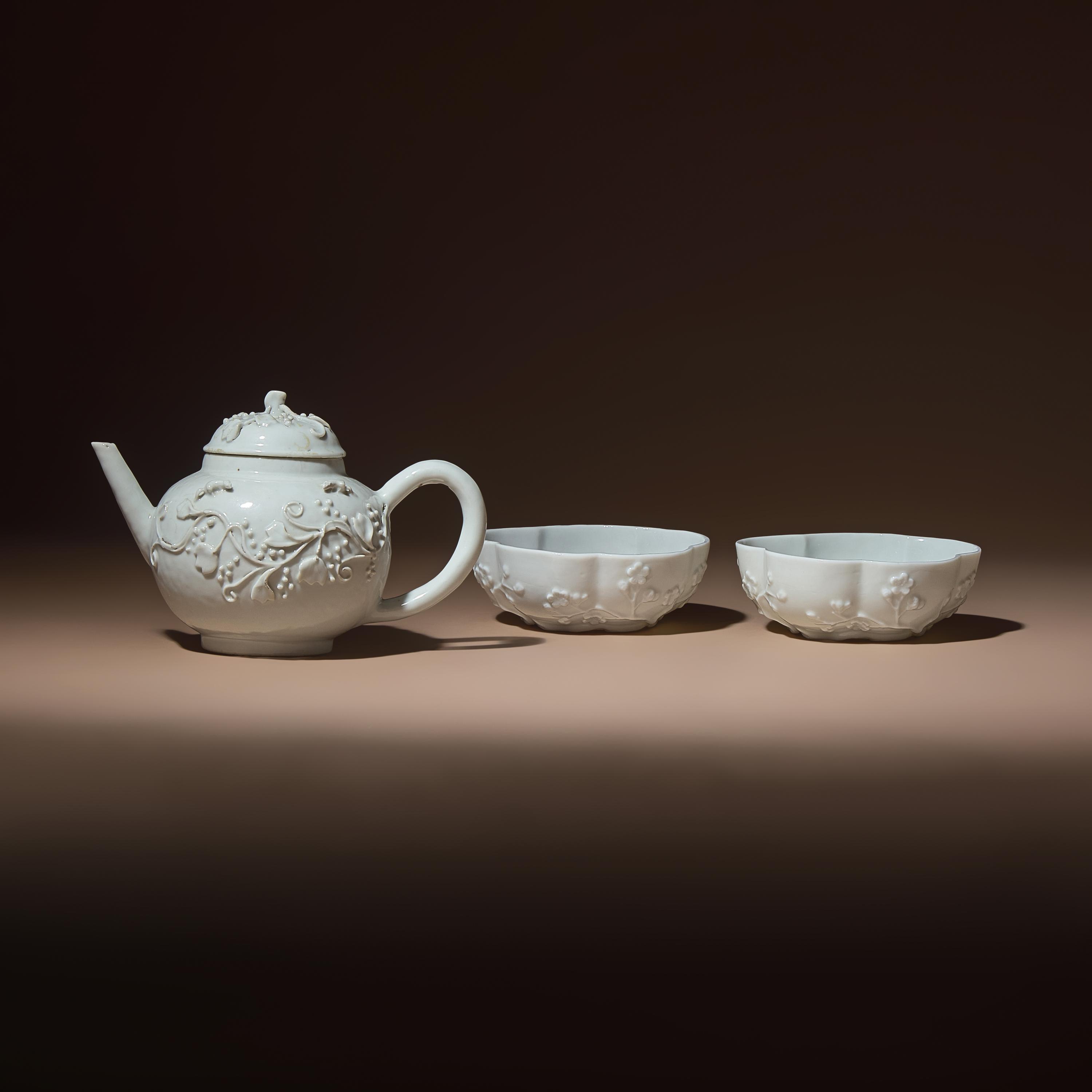 A Chinese Blanc-de-Chine Molded Porcelain Covered Teapot and a Pair of Molded Floriform Bowls, 18th Century — 清中期 德化白瓷貼塑松鼠葡萄茶壺及茶碗一對