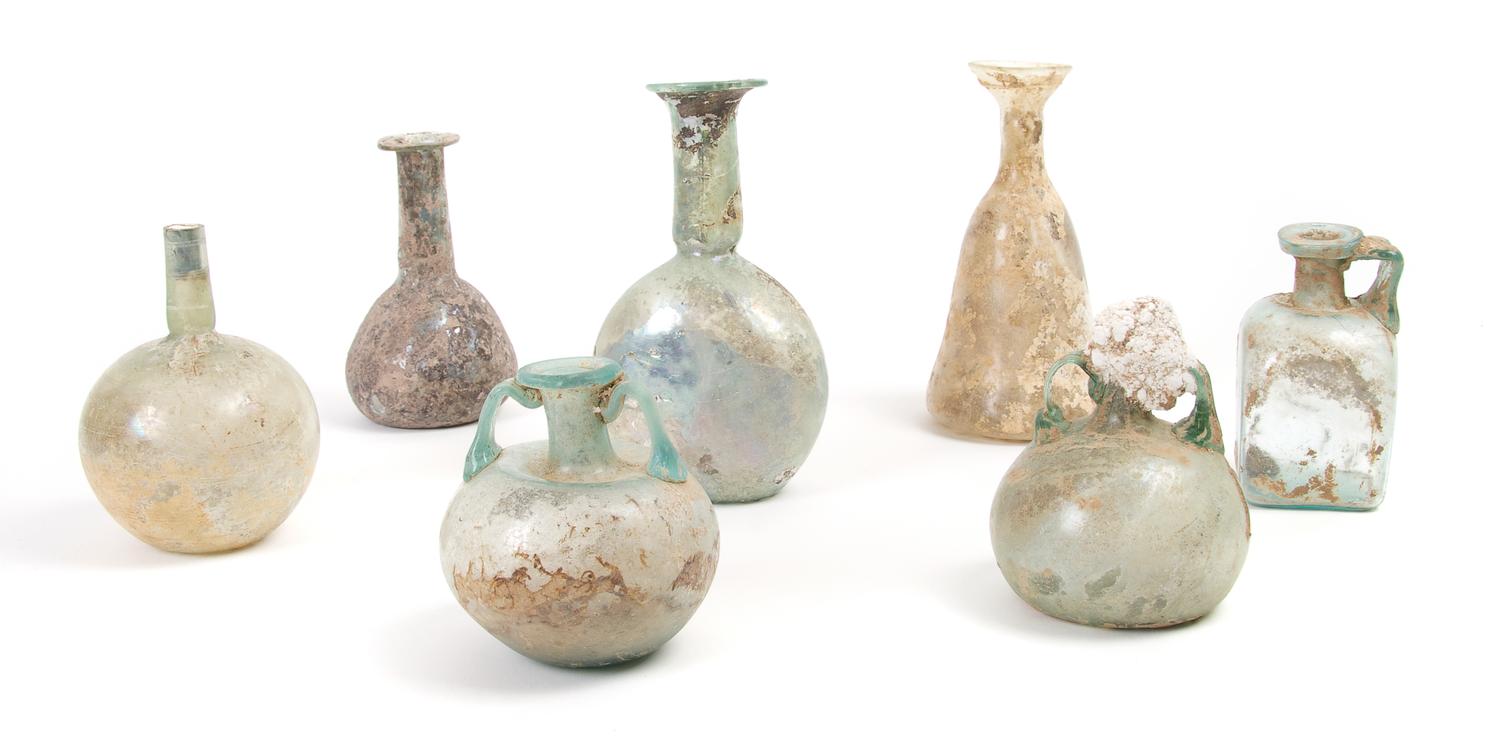 A Collection of Seven Roman Glass Bottles and Flasks, Height of tallest 6 inches.