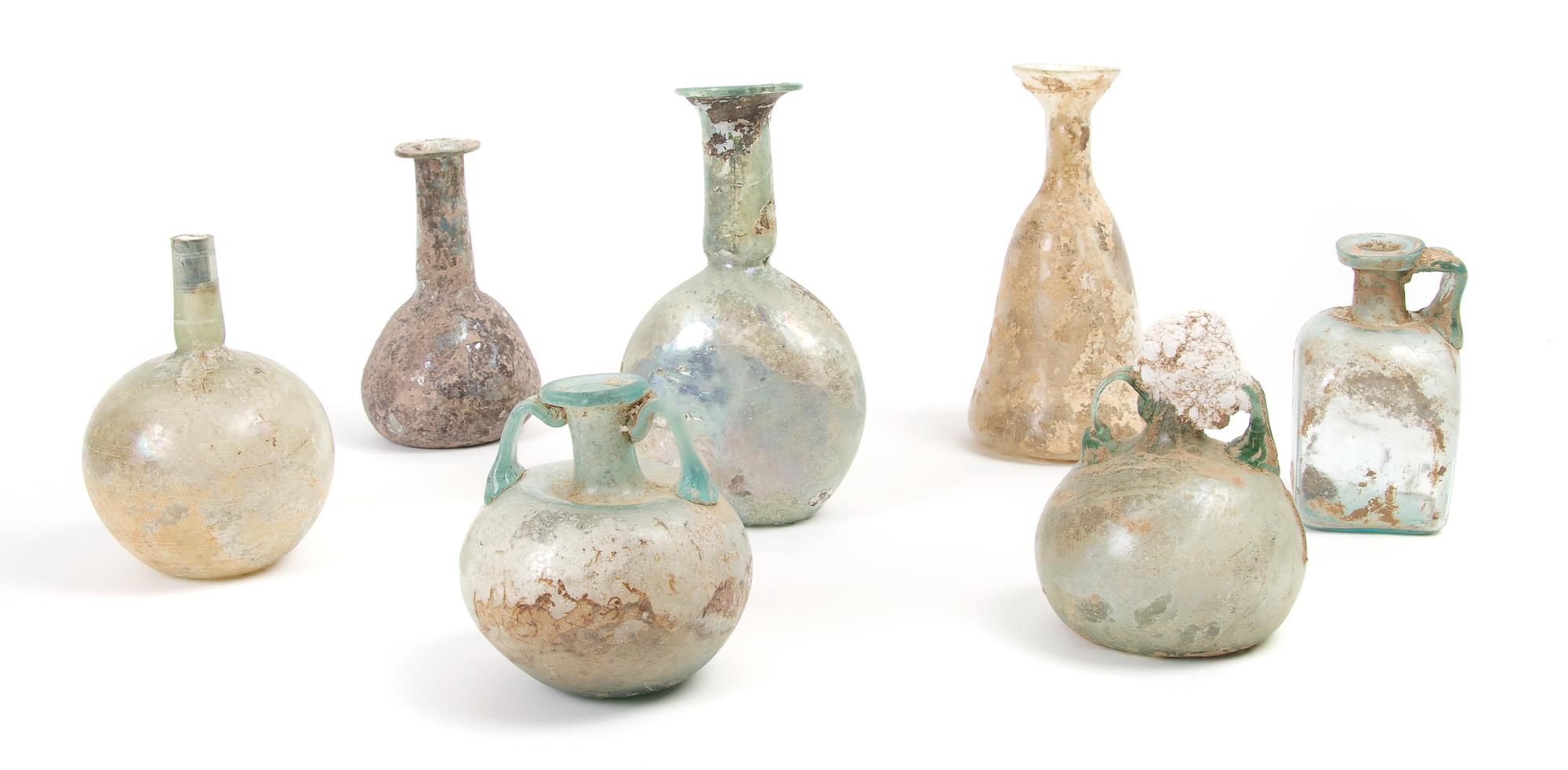 A Collection of Seven Roman Glass Bottles and Flasks, Height of tallest 6 inches.