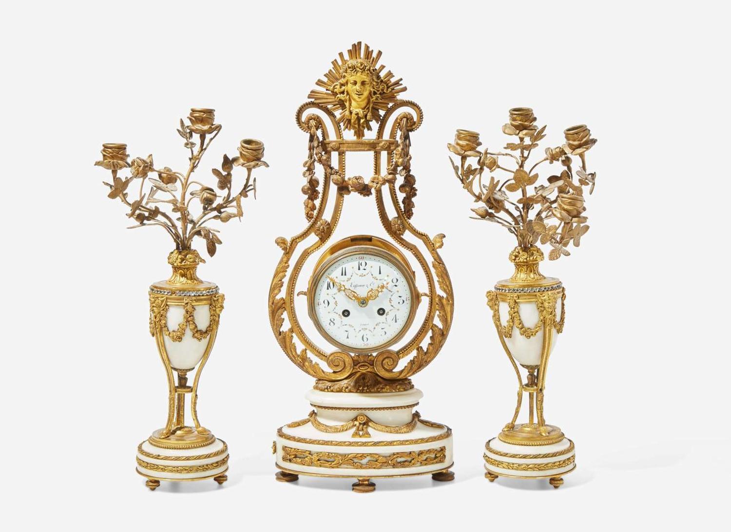 A French Louis XVI style three-piece gilt bronze and white marble clock garniture, retailed by Tiffany & Co., New York, NY, late 19th century