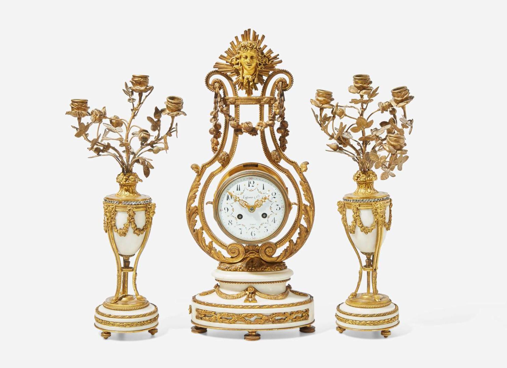 A French Louis XVI style three-piece gilt bronze and white marble clock garniture, retailed by Tiffany & Co., New York, NY, late 19th century