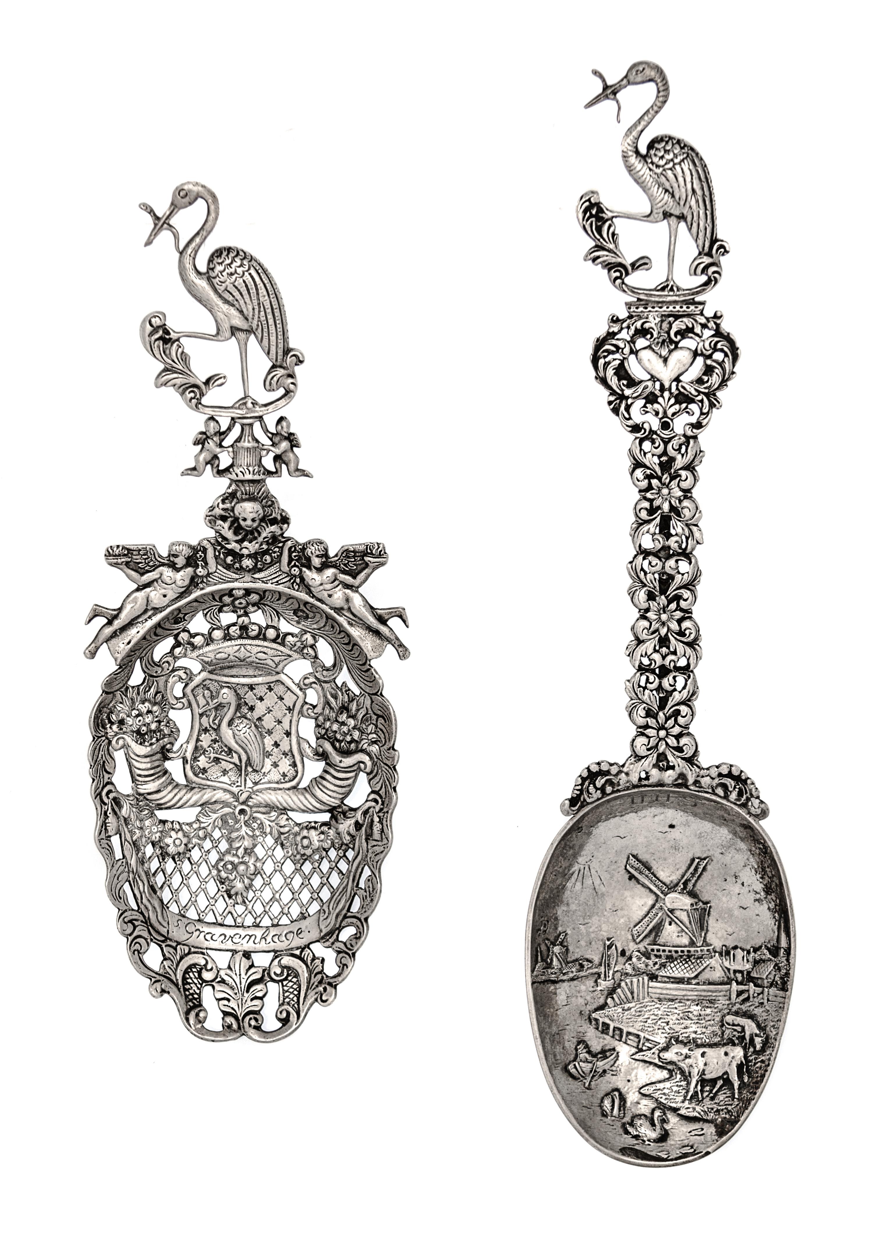 Two Dutch Silver Serving Spoons, Second Half 19th Century, comprsing a pierced example decorated with floral cornucopias and putti figu