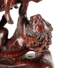 A Carved Wood Figural Group of a Young Man on Horseback Slaying a Lion