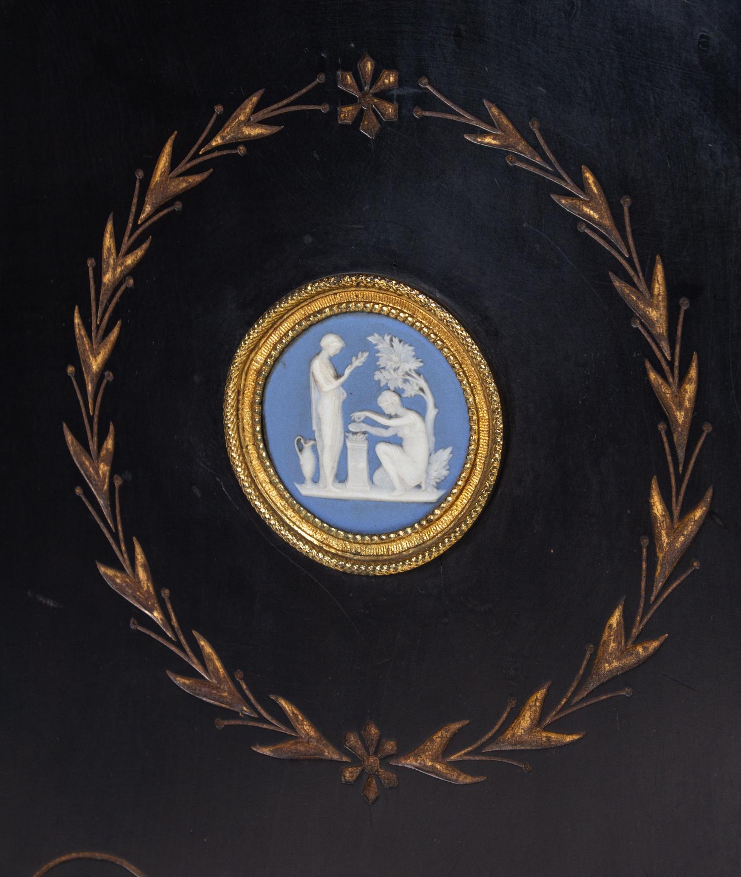 A Pair of English Aesthetic Jasperware Medallion-Mounted Ebonized and Parcel-Gilt Pedestal Cabinets