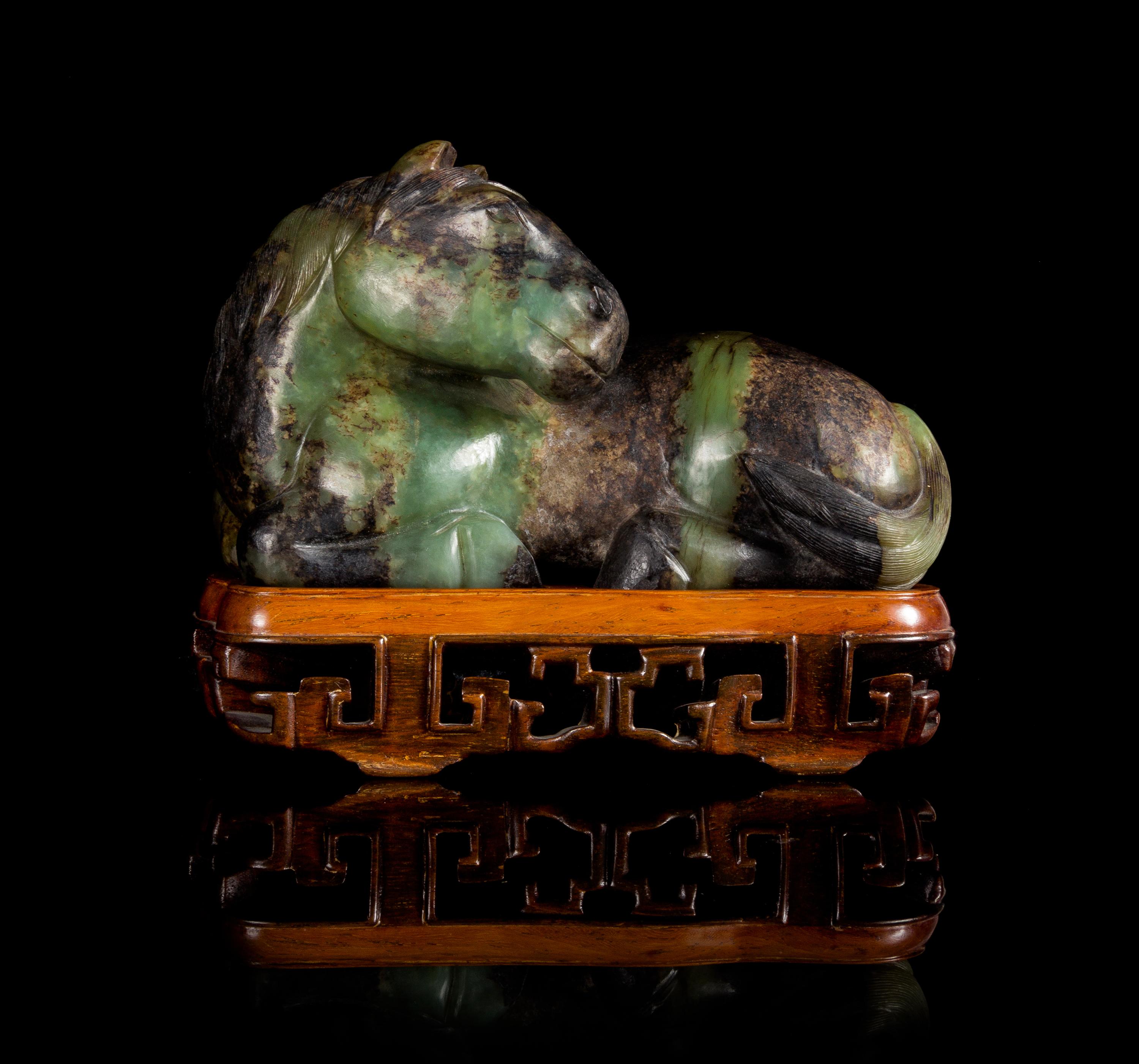 A Celadon and Russet Jade Figure of a Reclining Horse Length 6 1/4 inches.