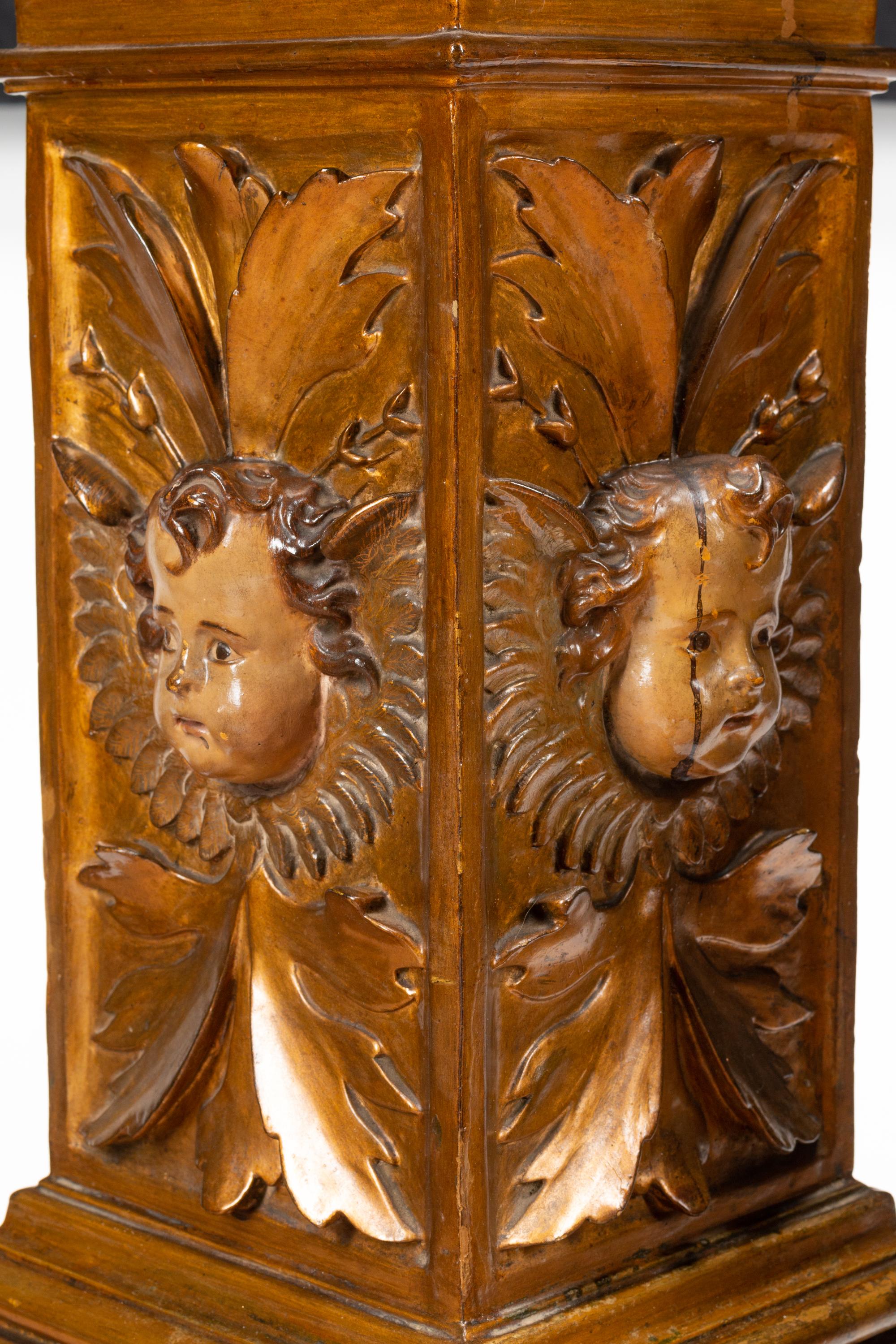 A Pair of Continental Faux Marble Painted and Gilt Pedestals with Putto Masks