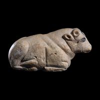 A Mesopotamian Limestone Recumbent Bull with Lapis Lazuli Inlays
