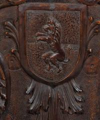 A Jacobean Style Carved Oak Bench with Armorial and Lion Carved Back