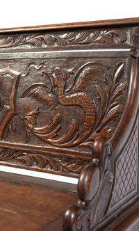 An Italian Renaissance Revival Carved Oak Settle